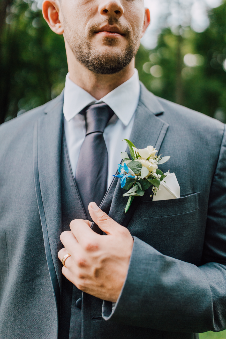  Closeup of a Groom’s boutonniere and gray 3-piece suit 