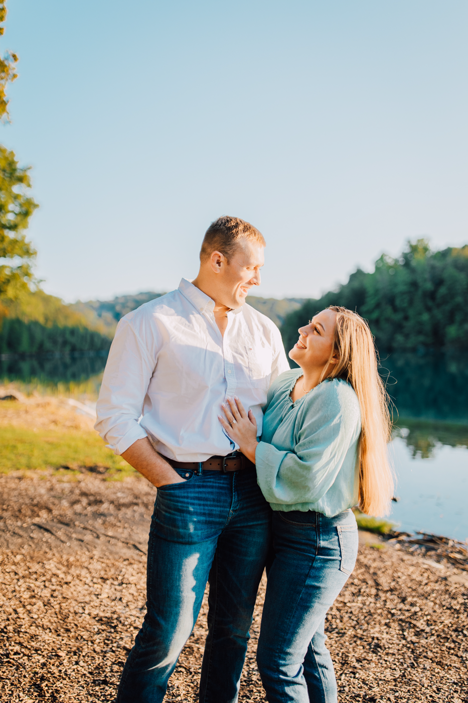  Engaged couple embrace during their lakeside engagement photos in Central NY at sunset 