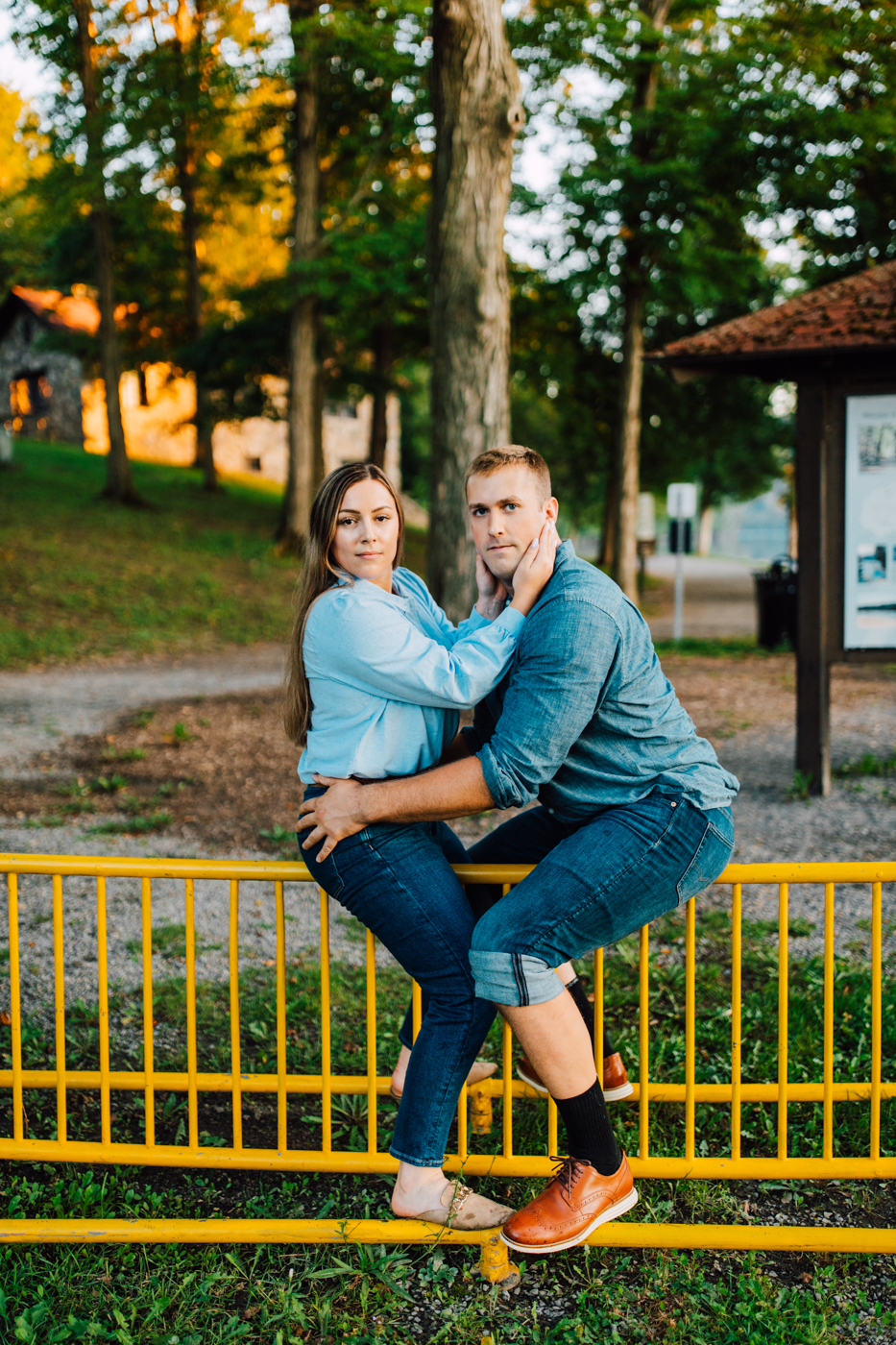  Engaged couple embraces while straddling a bike rack during their awkward photoshoot wearing all denim outfits 