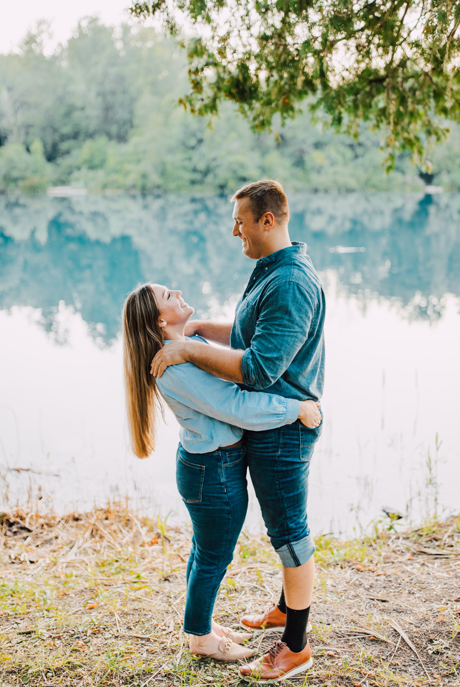  Engaged couple stands awkwardly in front of a lake during their funny engagement photos at Green Lakes State Park 