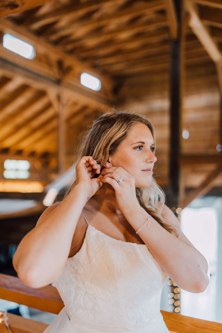  Bride puts in her earrings before her vow renewal at Rocking Horse Farm in Jamesville NY 