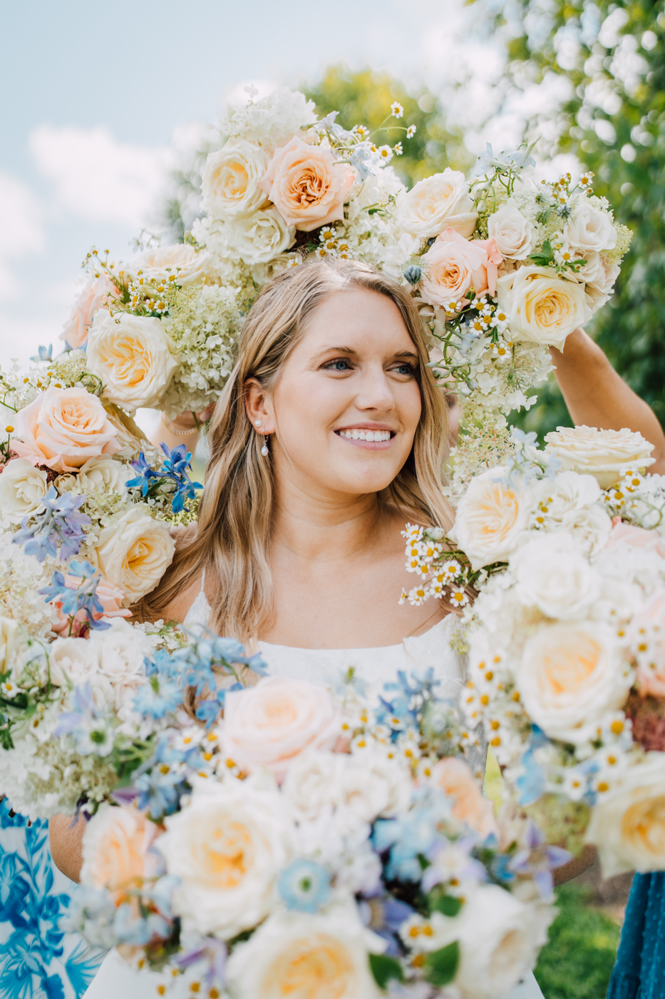  Bride smiles, surrounded by her Bridesmaids’ bouquets 