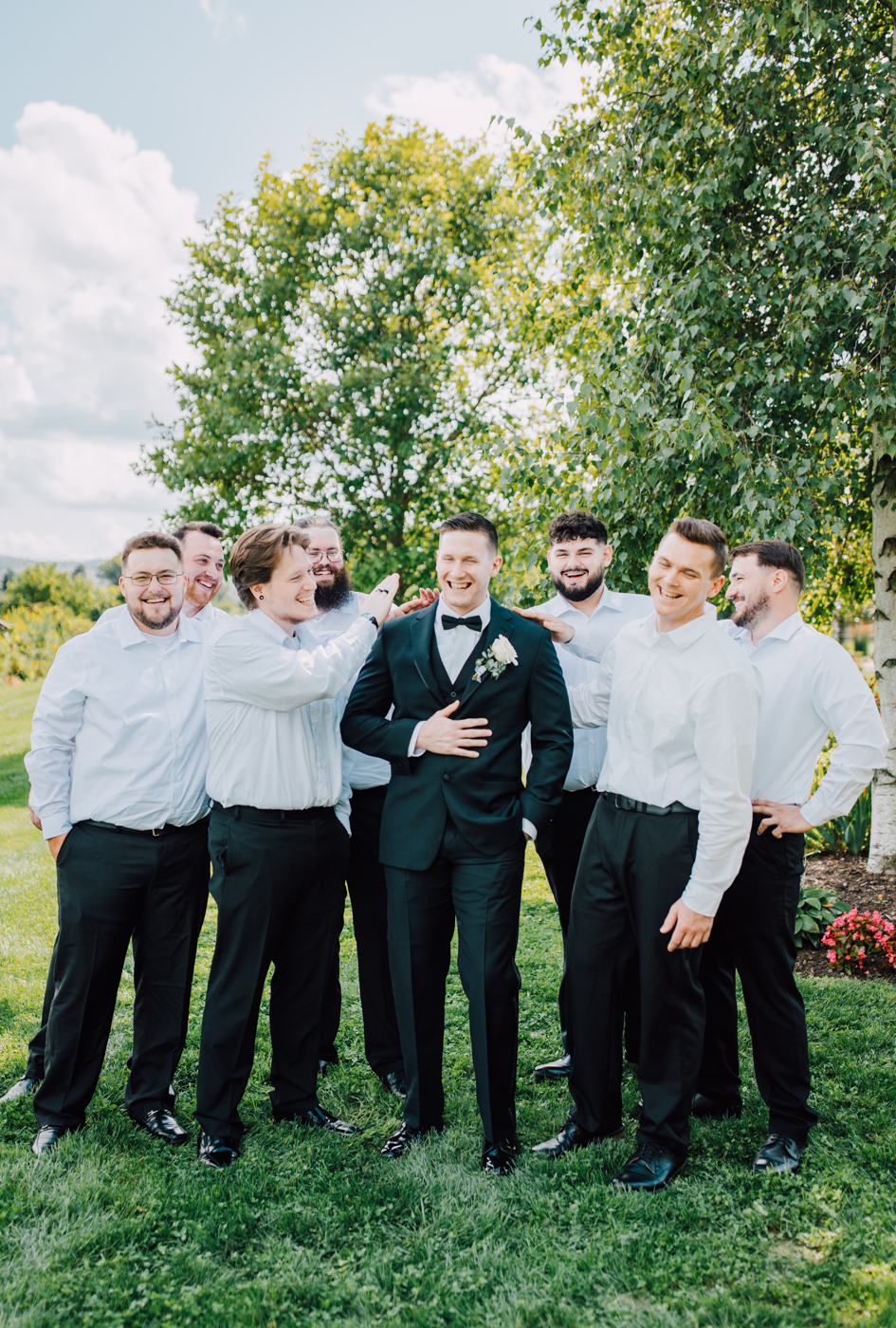  Groom stands with his Groomsmen, laughing 