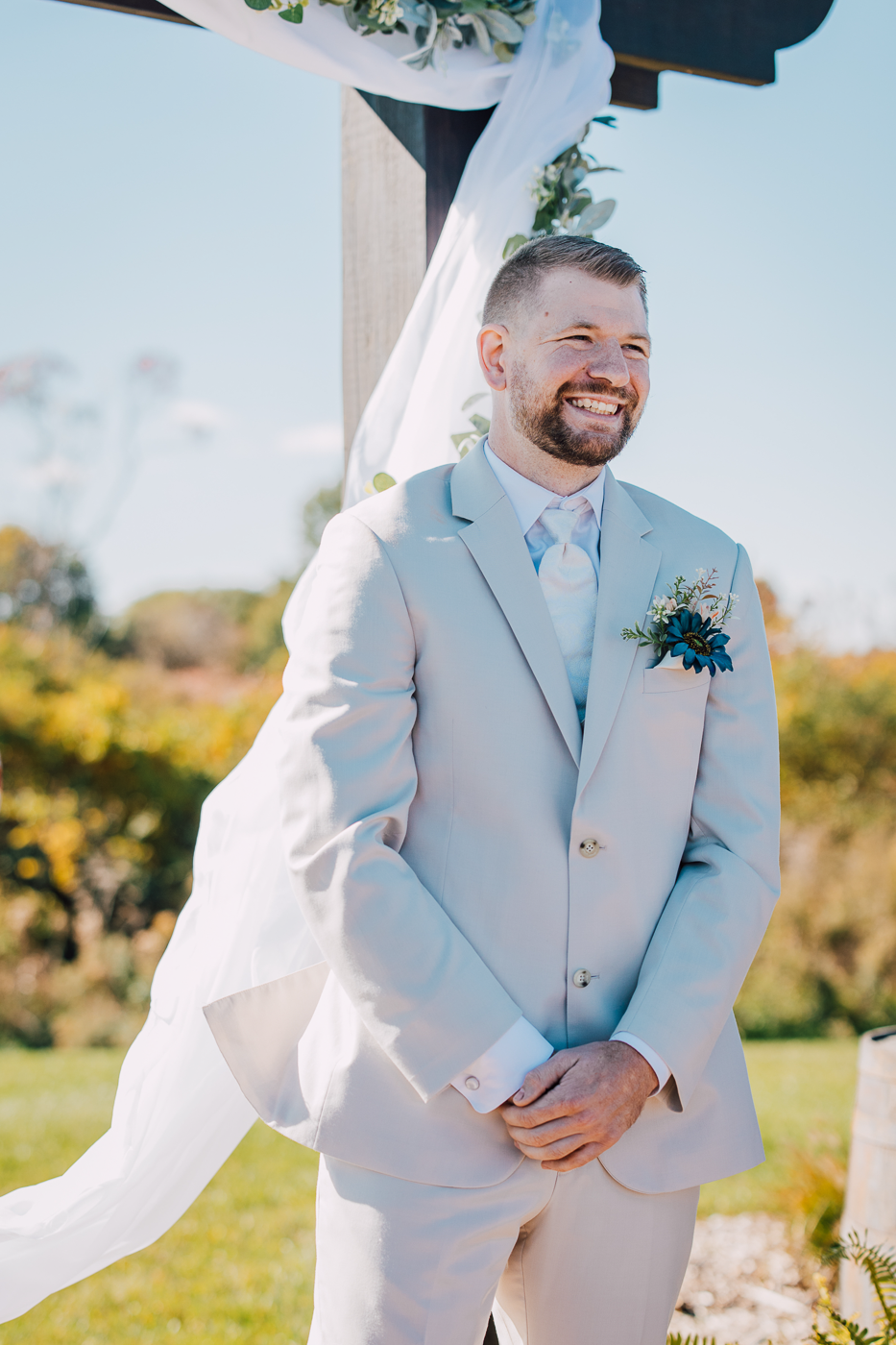  Groom grins as his Bride walks down the aisle during their outdoor wedding ceremony 