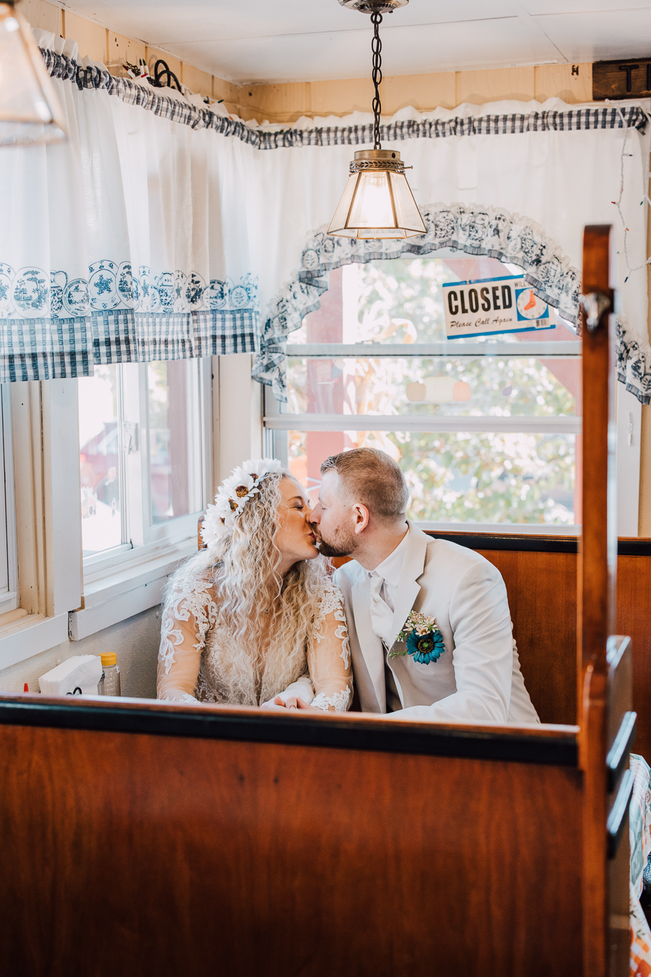  Bride and Groom kiss while sitting in a diner booth at That Little Place on Main in Little Falls NY 