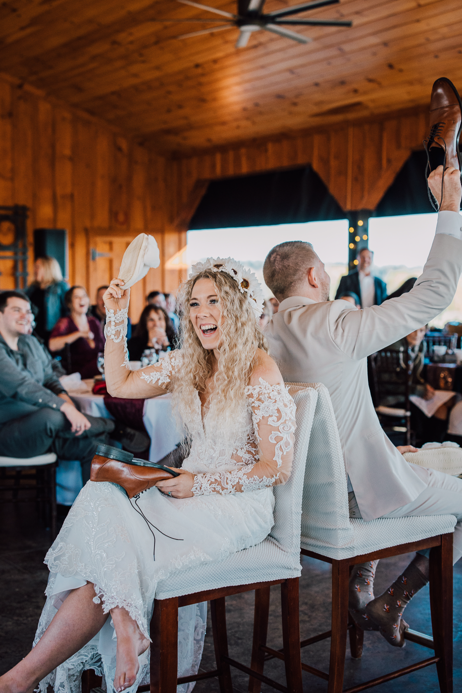  Bride holds up a slipper while playing the shoe game at her wedding reception 