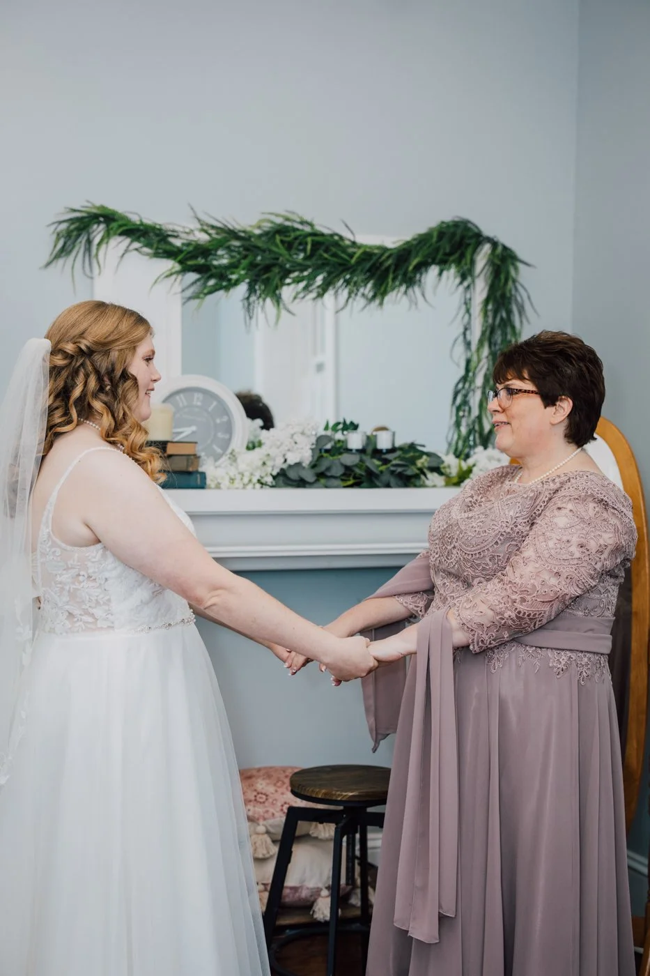  Bride and her mom holds hands while getting ready for her fall wedding at Curtis Manor   