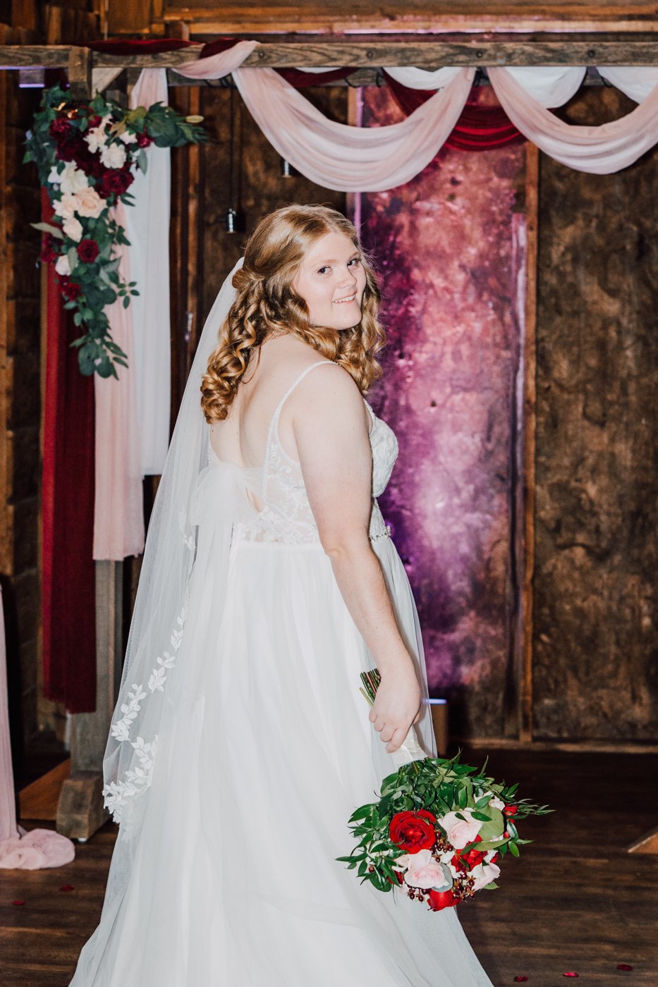  Bride shows off her veil and bouquet during indoor wedding photos for her fall wedding in Central NY 