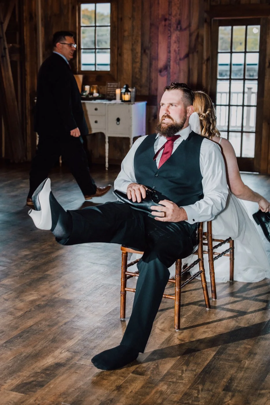  Groom makes a face as he tries on the Bride’s shoe during the Shoe Game 