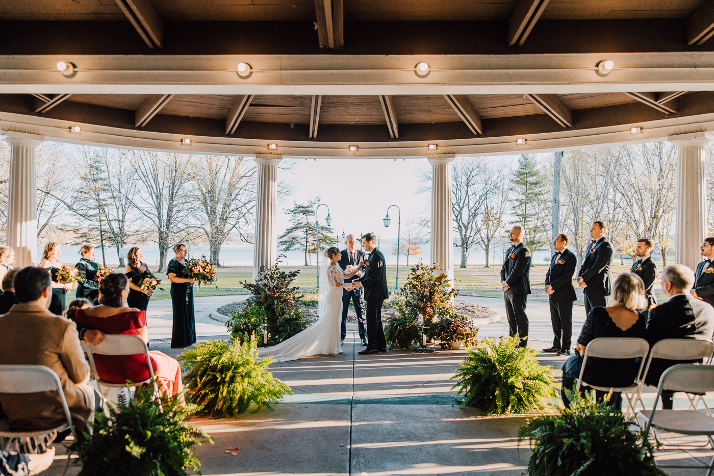 Outdoor wedding ceremony in November with ferns lining the aisle at Emerson Park Pavilion