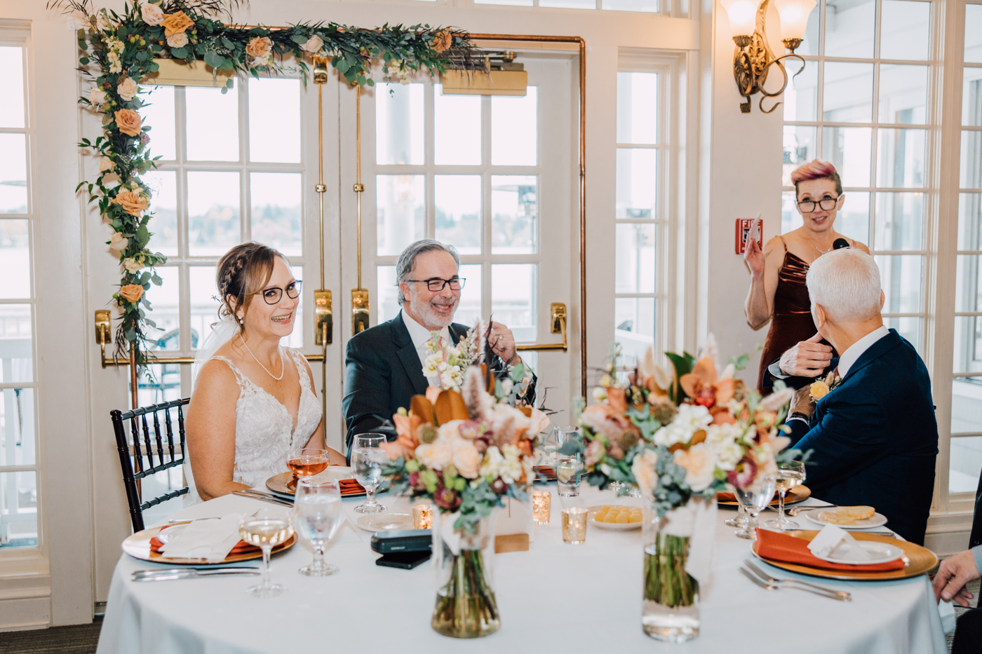 Bride and Groom listen to the Maid of Honor's speech during their country club wedding reception at Skaneateles Lake