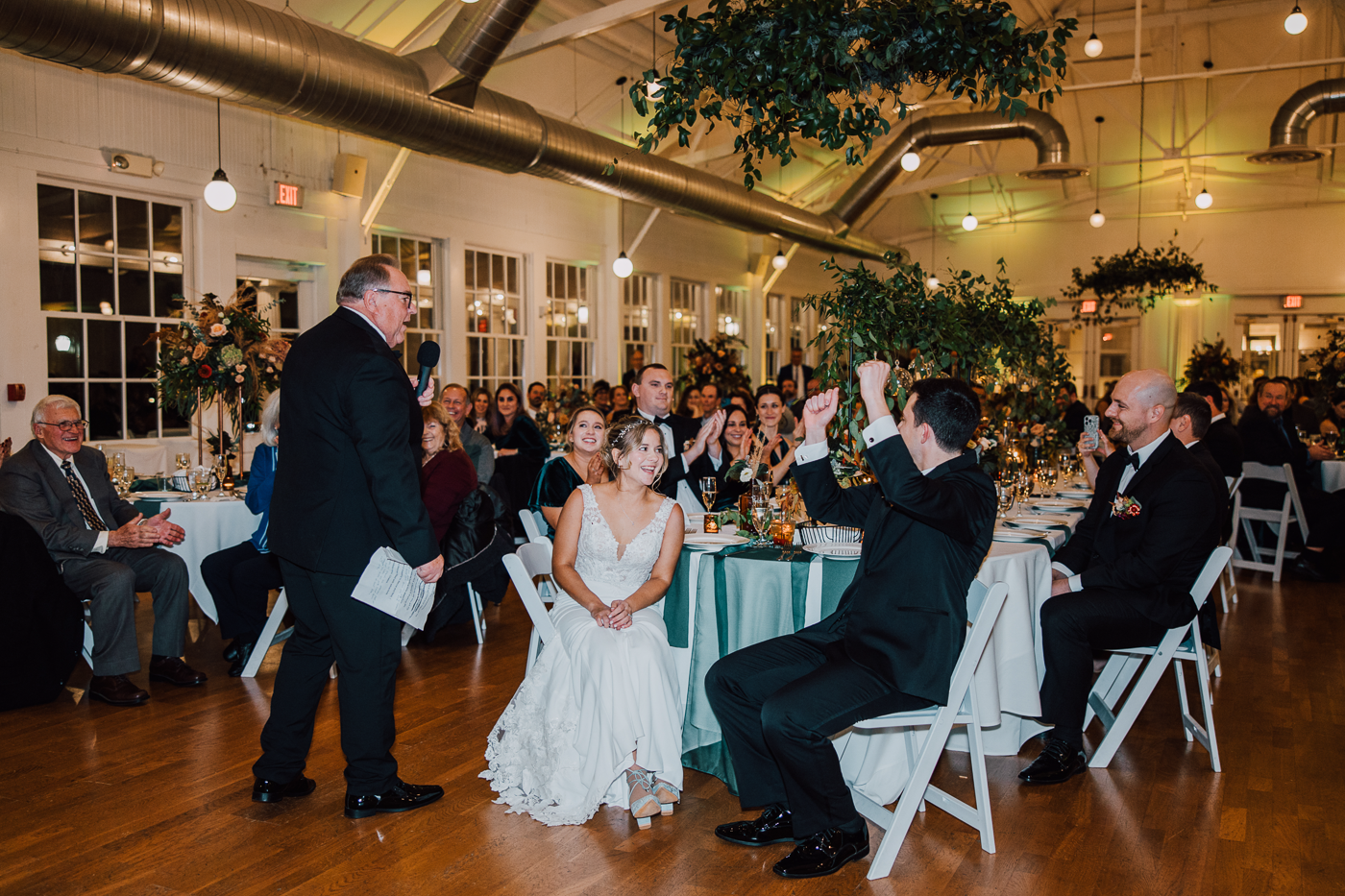 Bride and Groom laugh and cheer during toasts