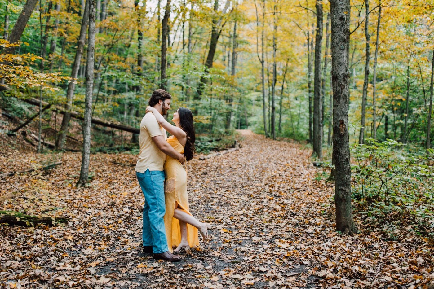 Engaged couple embrace in the forest at Labrador Hollow while taking sunrise engagement photos