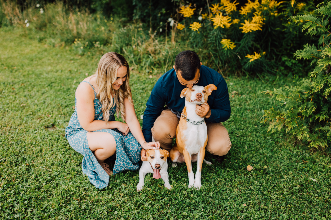 Engaged couple pets and kisses their dogs during an engagement session with Brittany Juravich in Central NY