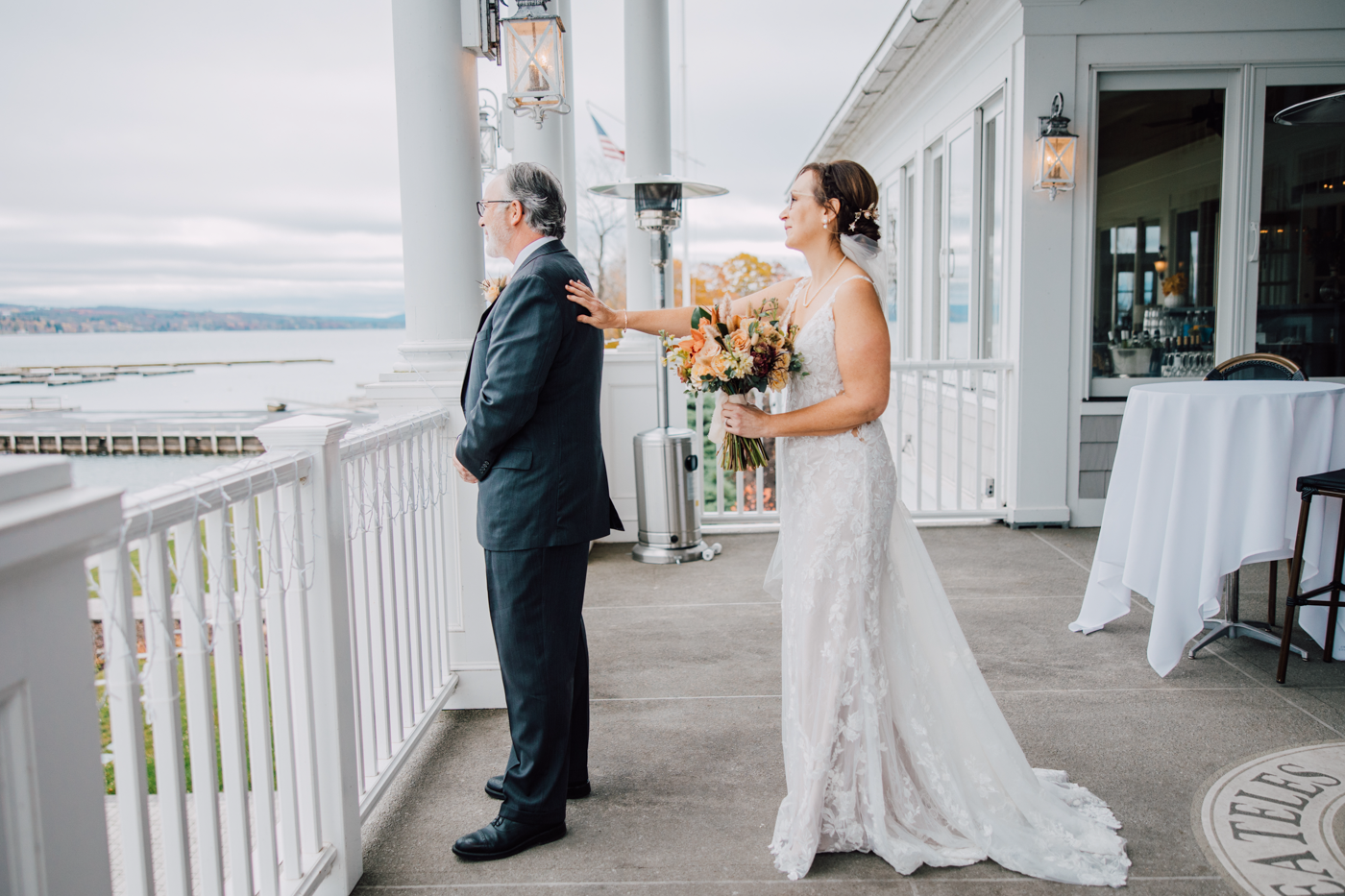 Bride taps her Groom on the shoulder during their wedding first look overlooking Skaneateles Lake in Central NY