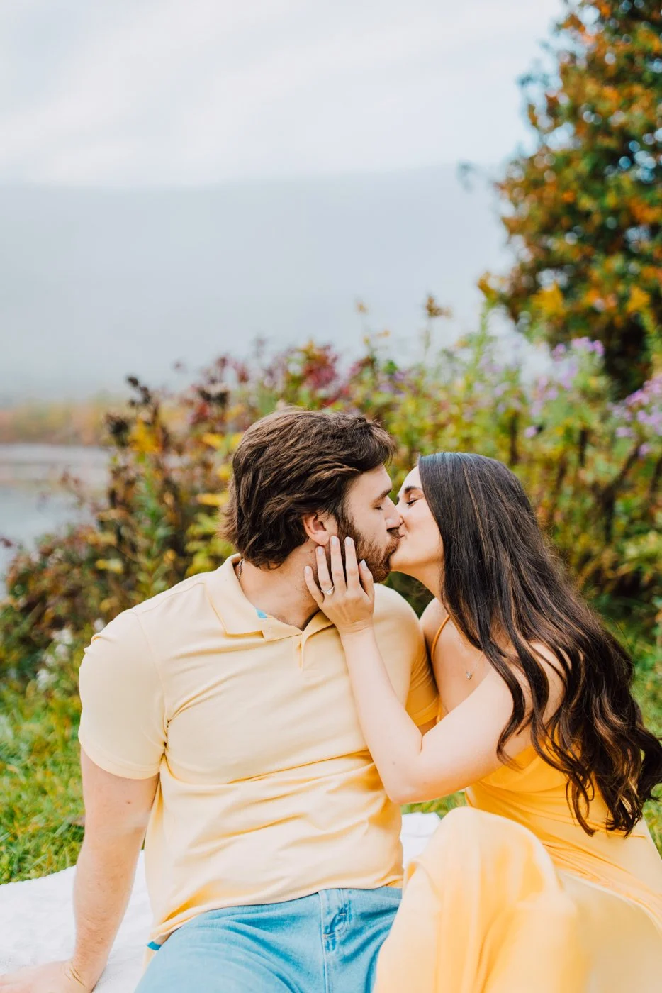 Engaged couple kisses on a blanket at Labrador Hollow during a foggy photoshoot
