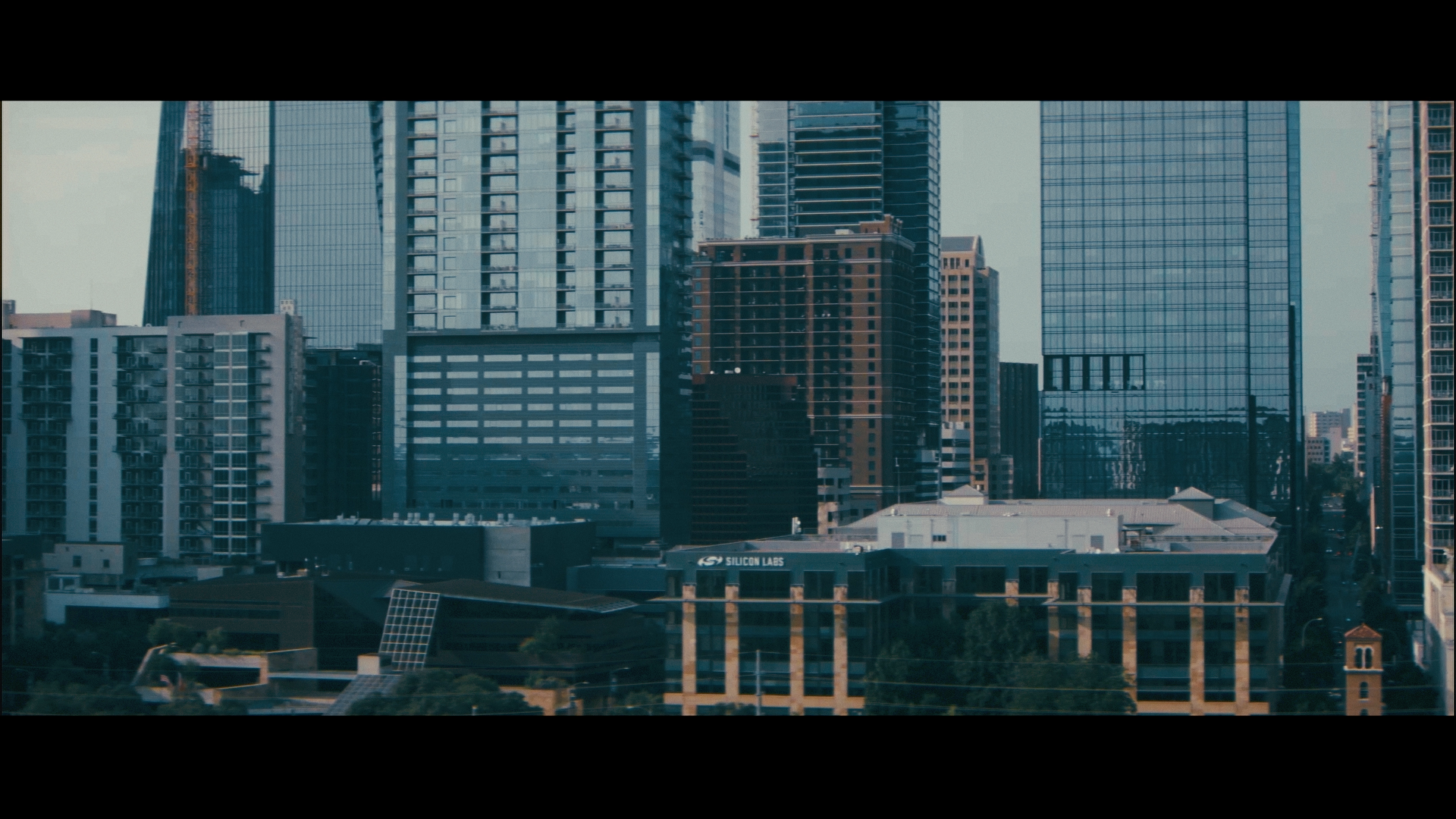 City skyline with modern skyscrapers and office buildings, including glass, steel, and concrete structures.