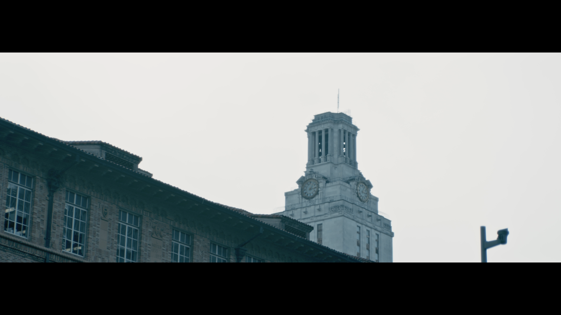Clock tower on top of an old brick building, with a cloudy sky in the background.