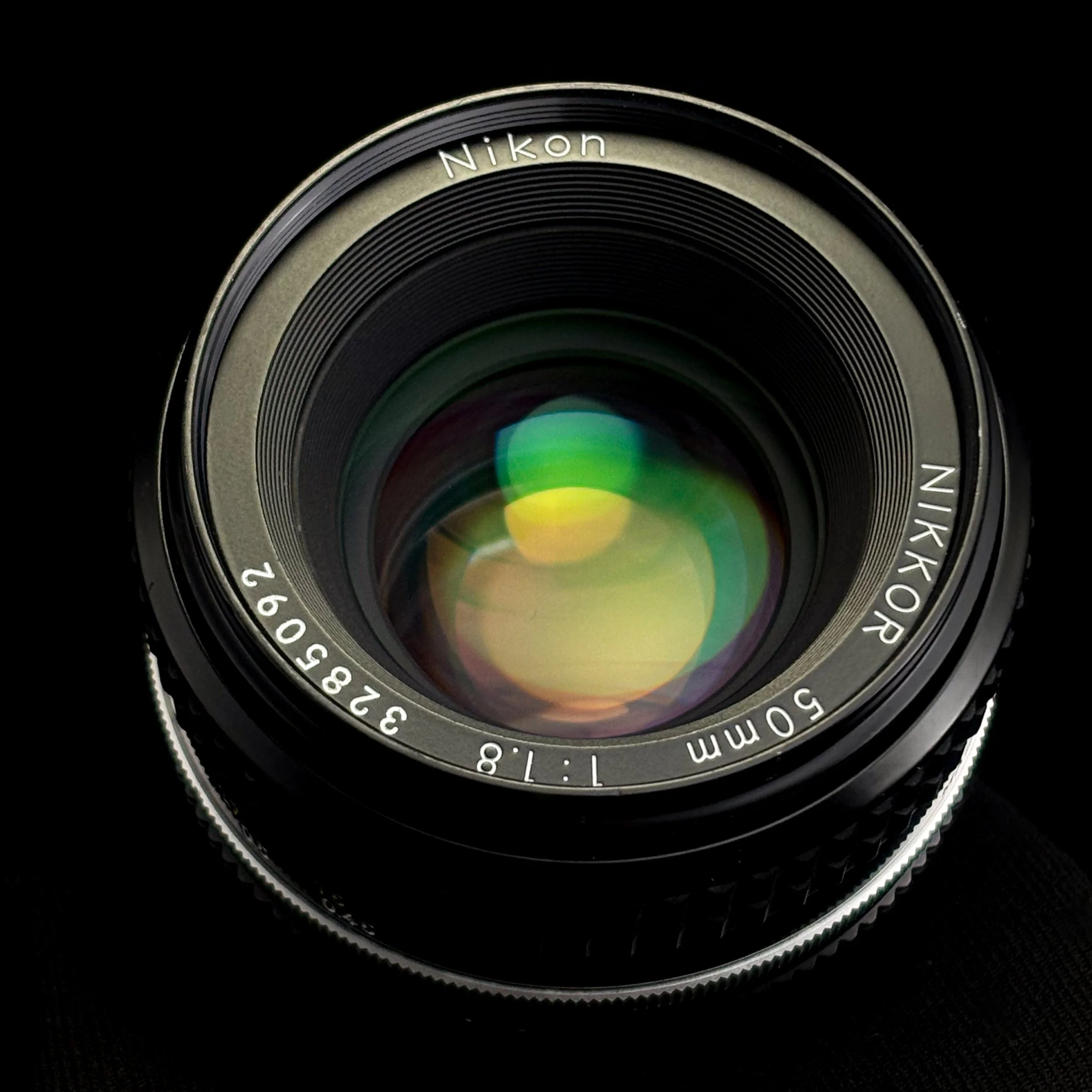Close-up of a Nikon Nikkor 50mm camera lens against a black background.