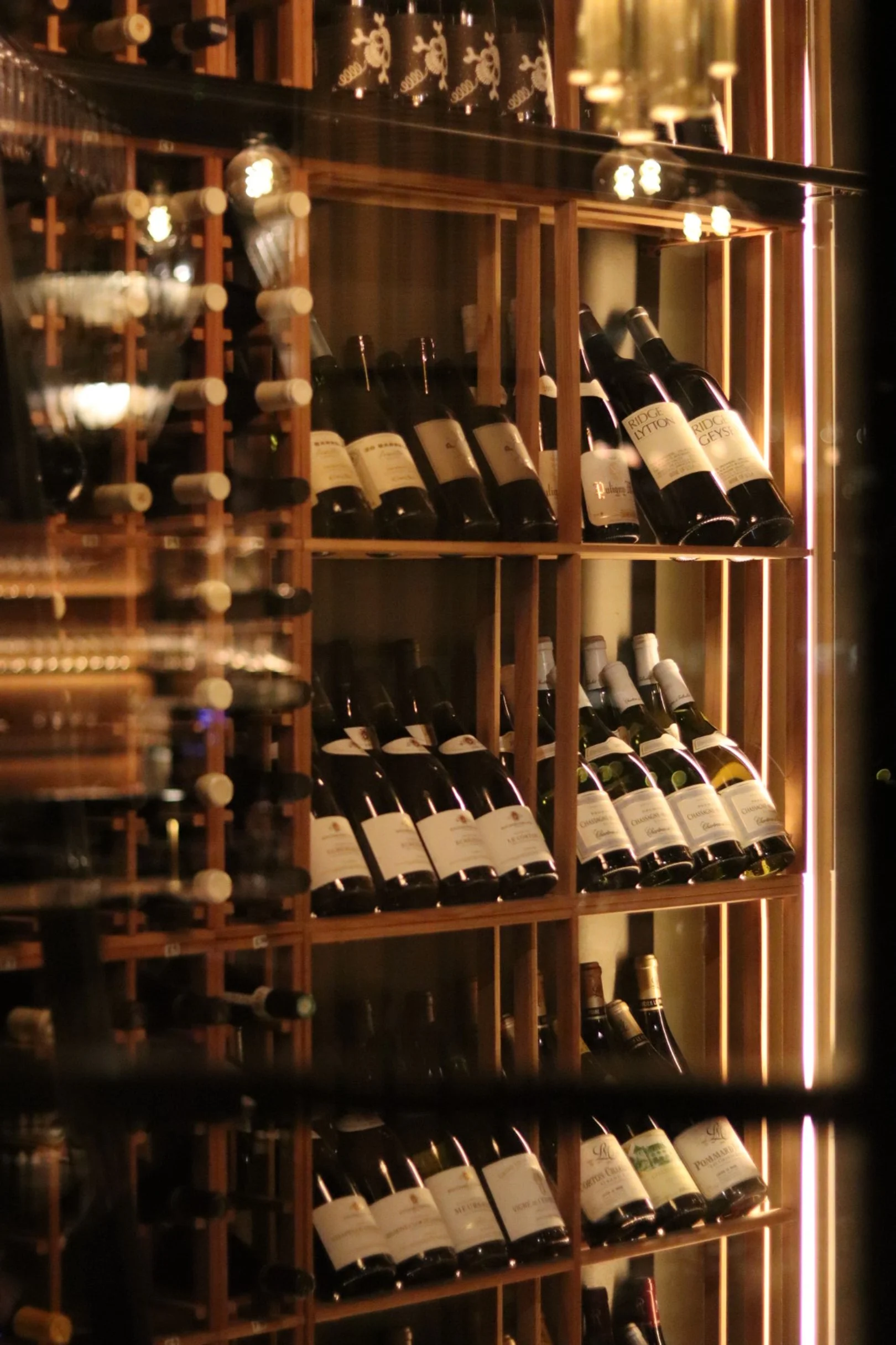 Vinskap med utvalgte flasker, belyst i varme toner inne hos Amazonia by BAR.