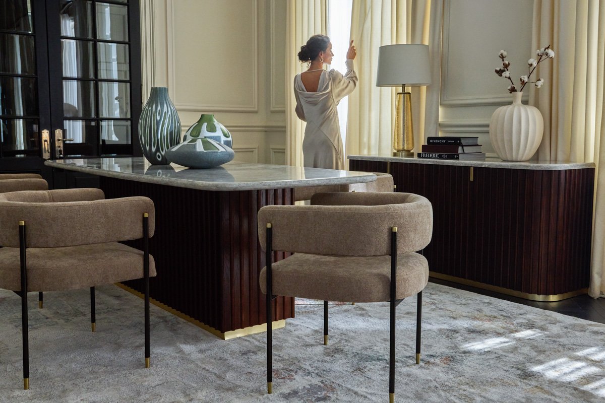 An elegant, open-plan dining room showcasing premium furniture sets and warm ambient light, by Bakkes Images.