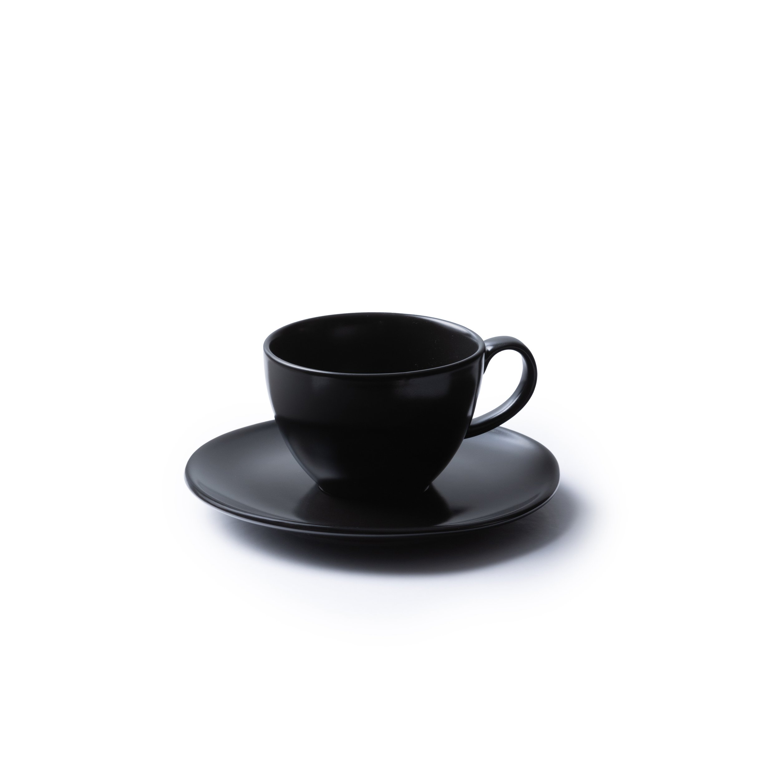 A black ceramic tea cup and saucer commercial product pack on white background shot by Bakkes Images, Stellenbosch studio.