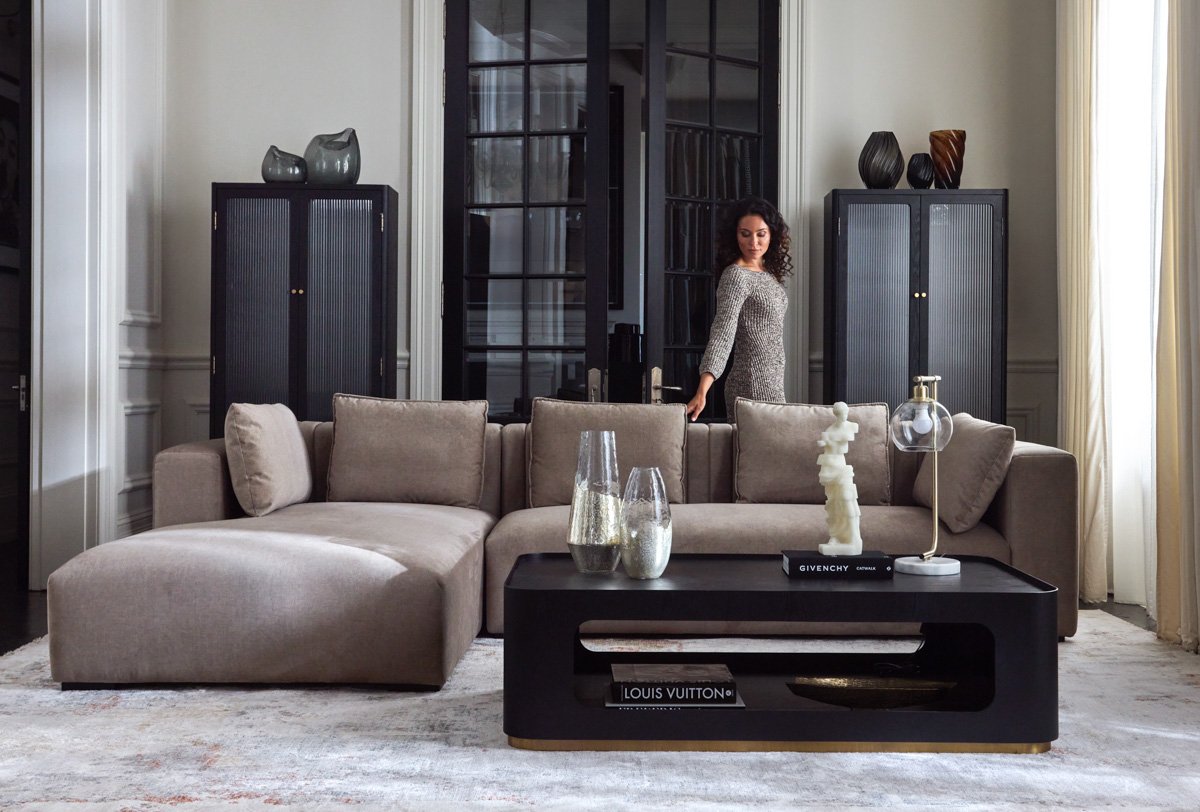 Luxury studio catalog layout featuring a modular grey sectional sofa and a low black coffee table, by Bakkes.