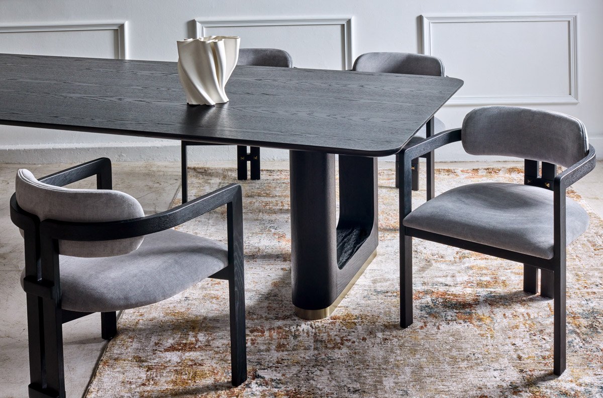 A modern black home office desk paired with sculptural grey executive chairs, photographed by Bakkes Images.