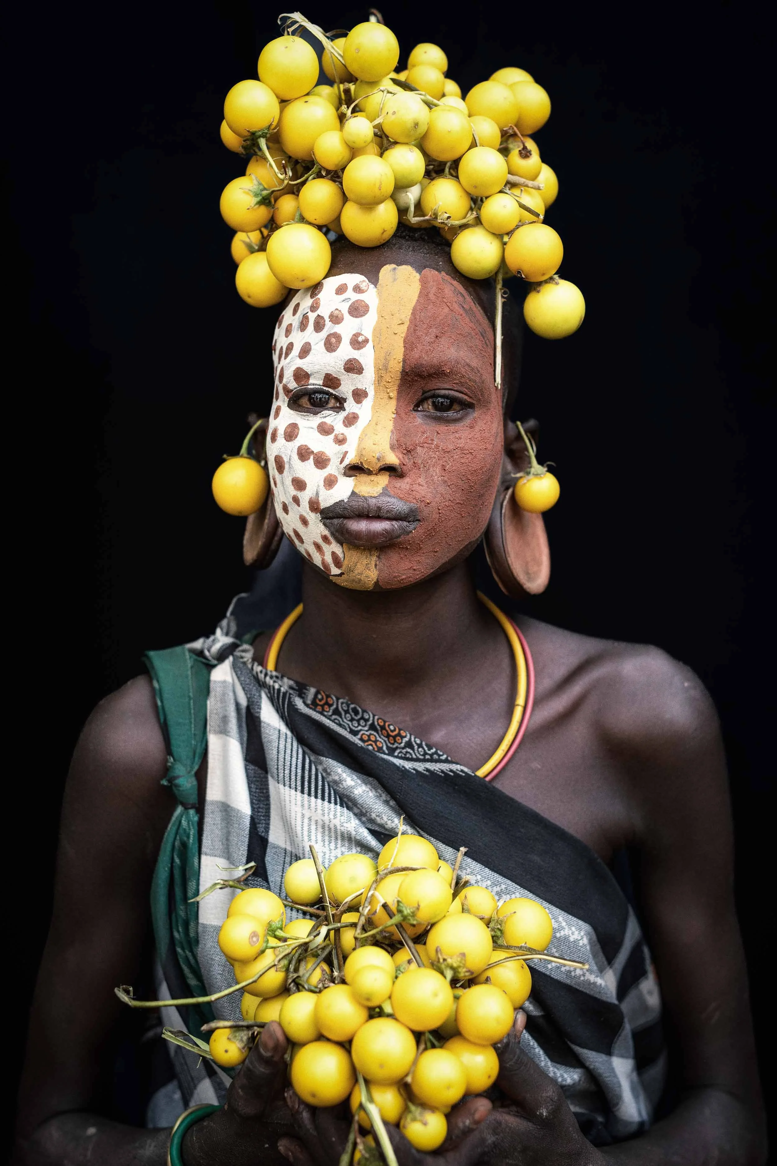 Suri girl with fruit headdress and painted face, Ethiopia