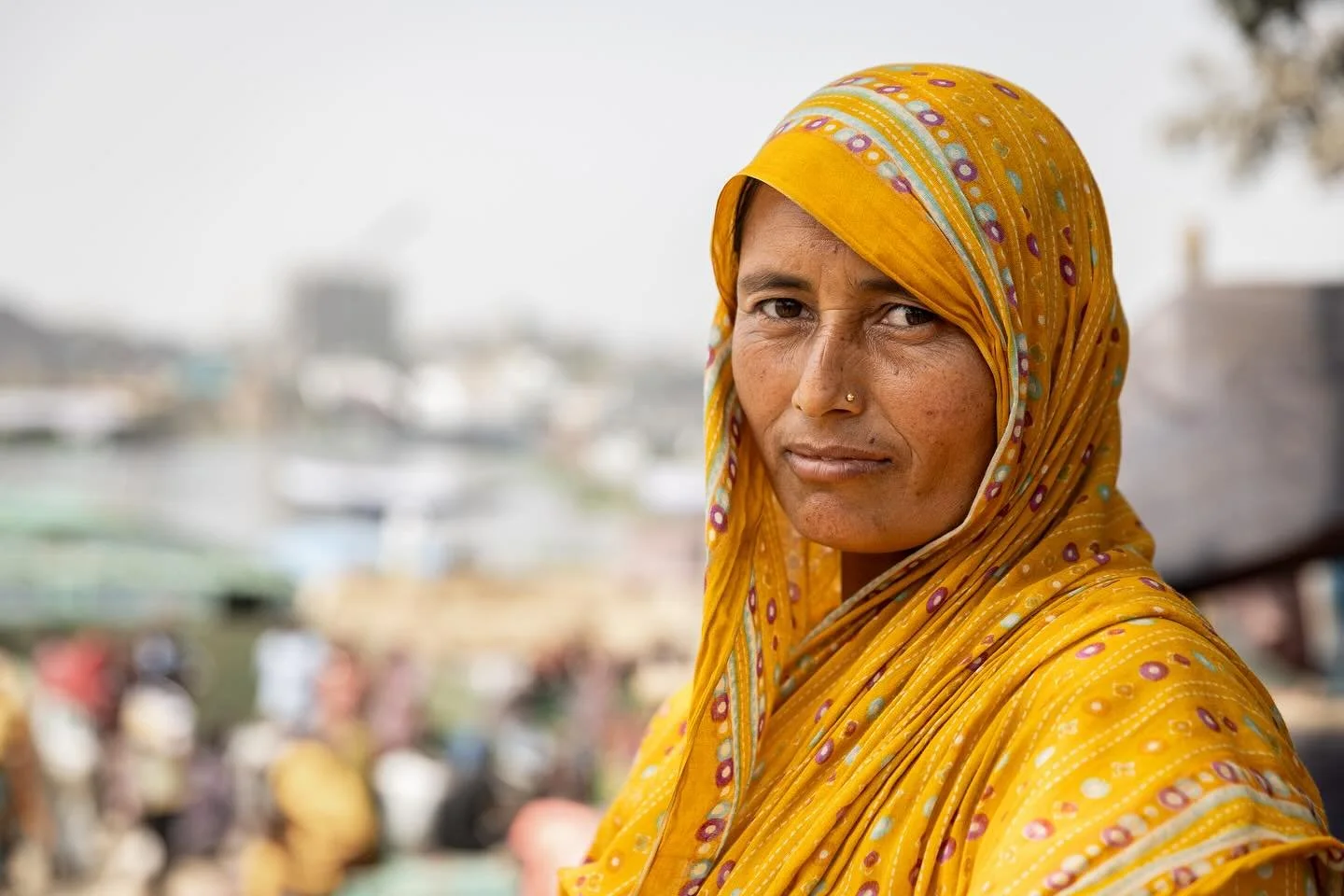 The people in Bangladesh work hard for the paltry amount of money they earn each day. This lady was one of a small number of women carrying loads of sand off a barge in baskets on their heads. Yet, despite the heat and the manual nature of the work, 