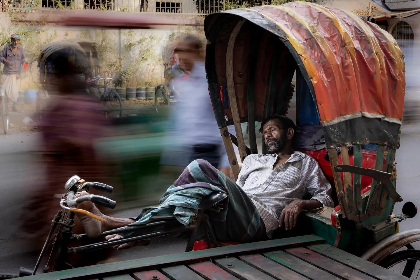 In a city that rarely seems to pause, a rickshaw driver sleeps while life moves past in a blur. 

Dhaka, Bangladesh 2026

#dhaka #bangladesh #streetphotography #documentaryphotography #myjourneywithacamera