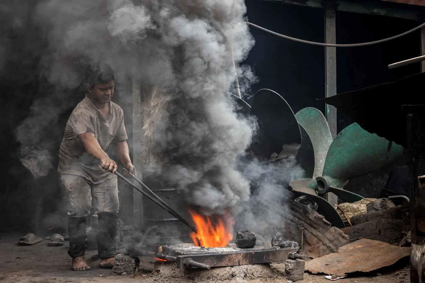 In the small streets and alleys behind the ship repair yards that line the Buriganga  River are a myriad of workshops repairing and manufacturing parts. 

That street housing the propeller workshops was, in places, an inferno of flames, dust and thic