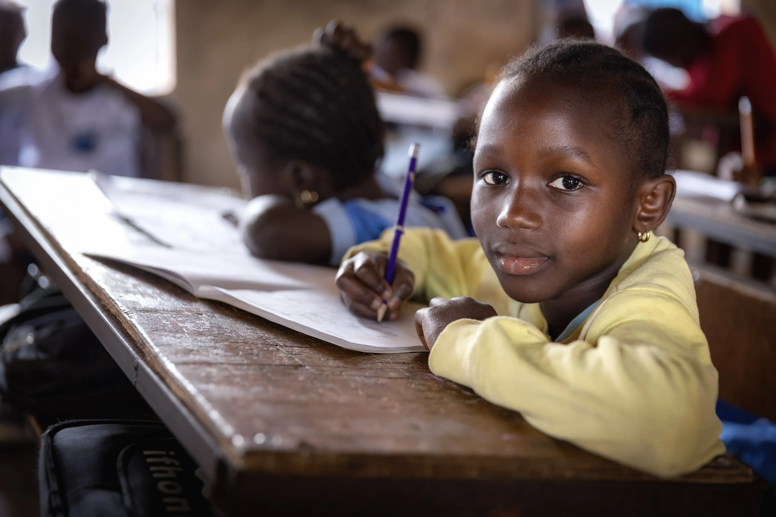 Girl writing at school desk, Gambia
