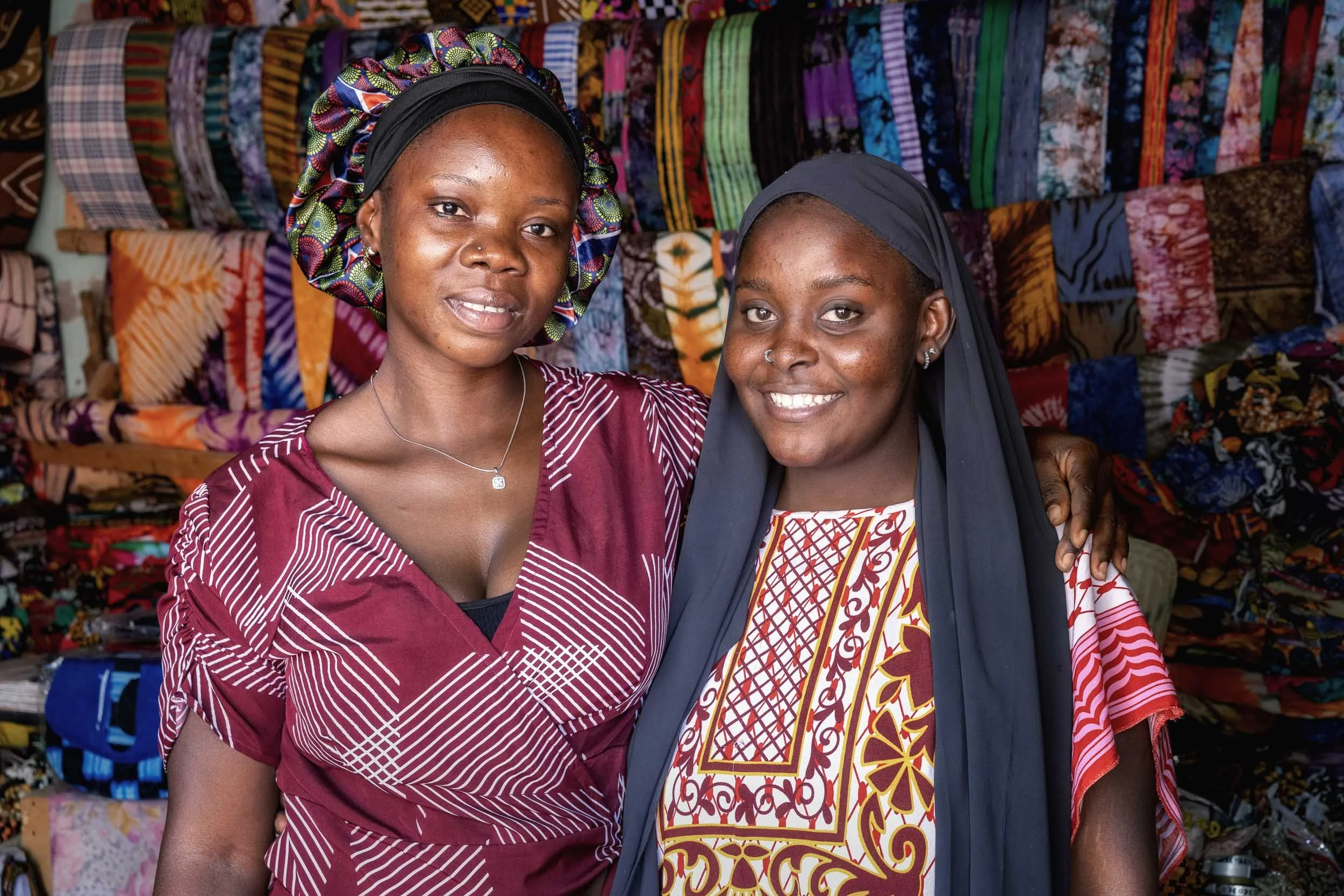 Two girls posing in fabric shop, Gambia