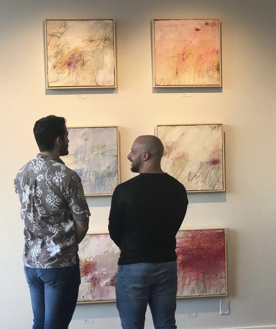 Two men discussing Crystal Michelson's art in a gallery