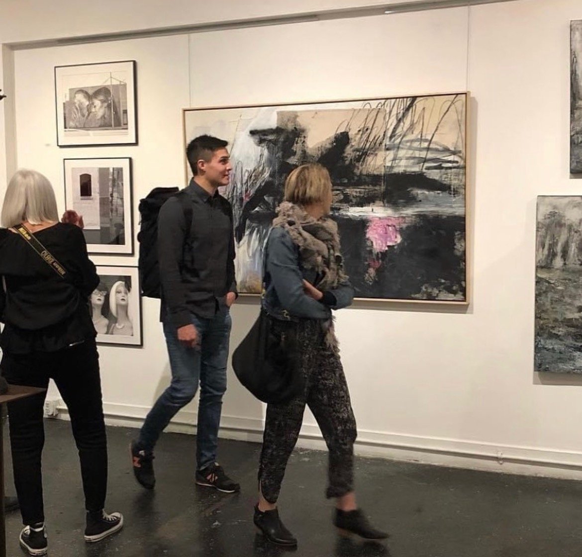 A man and woman looking at Crystal Michelson's art