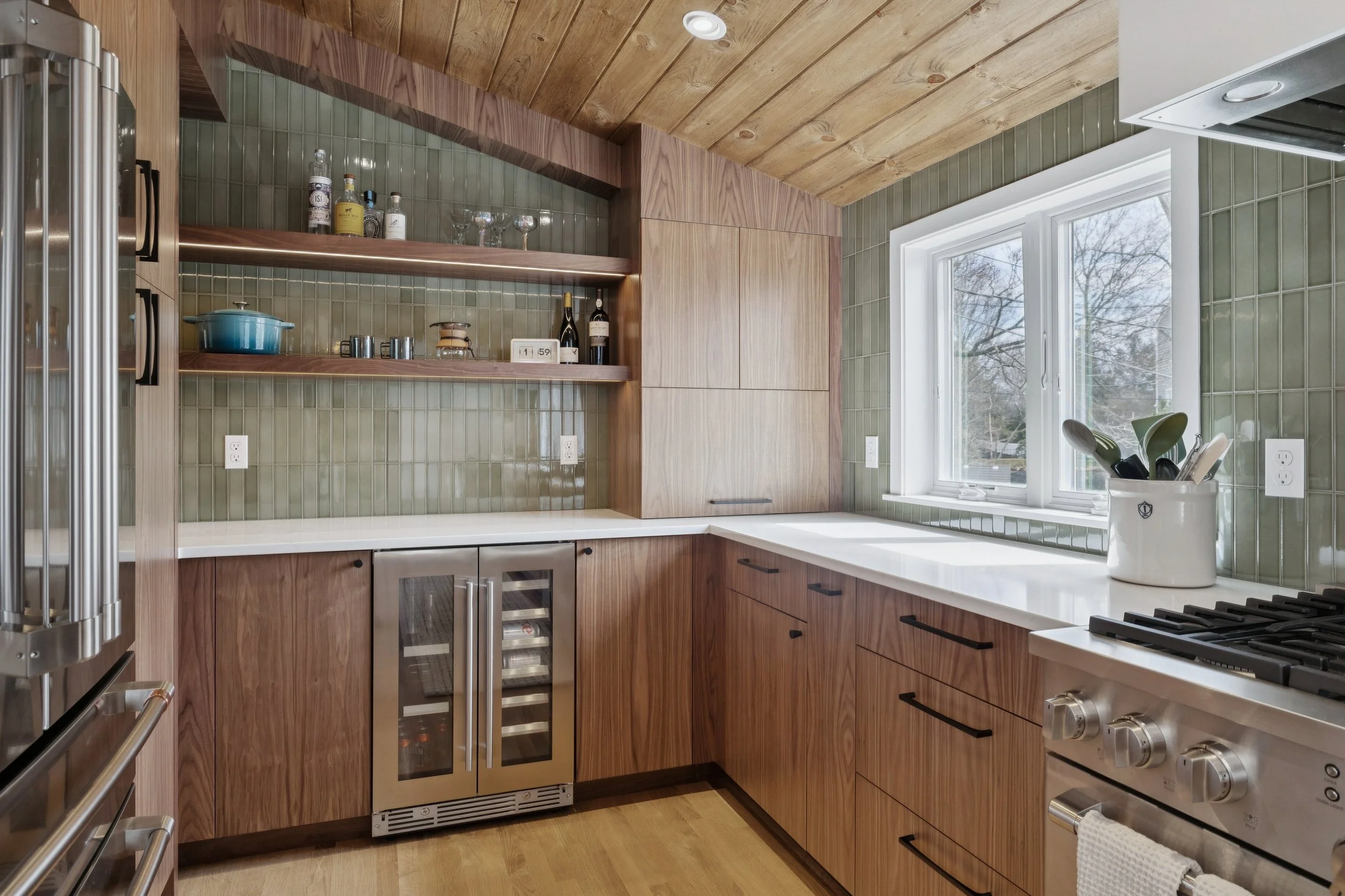 wooden cabinets in kitchen with green tile