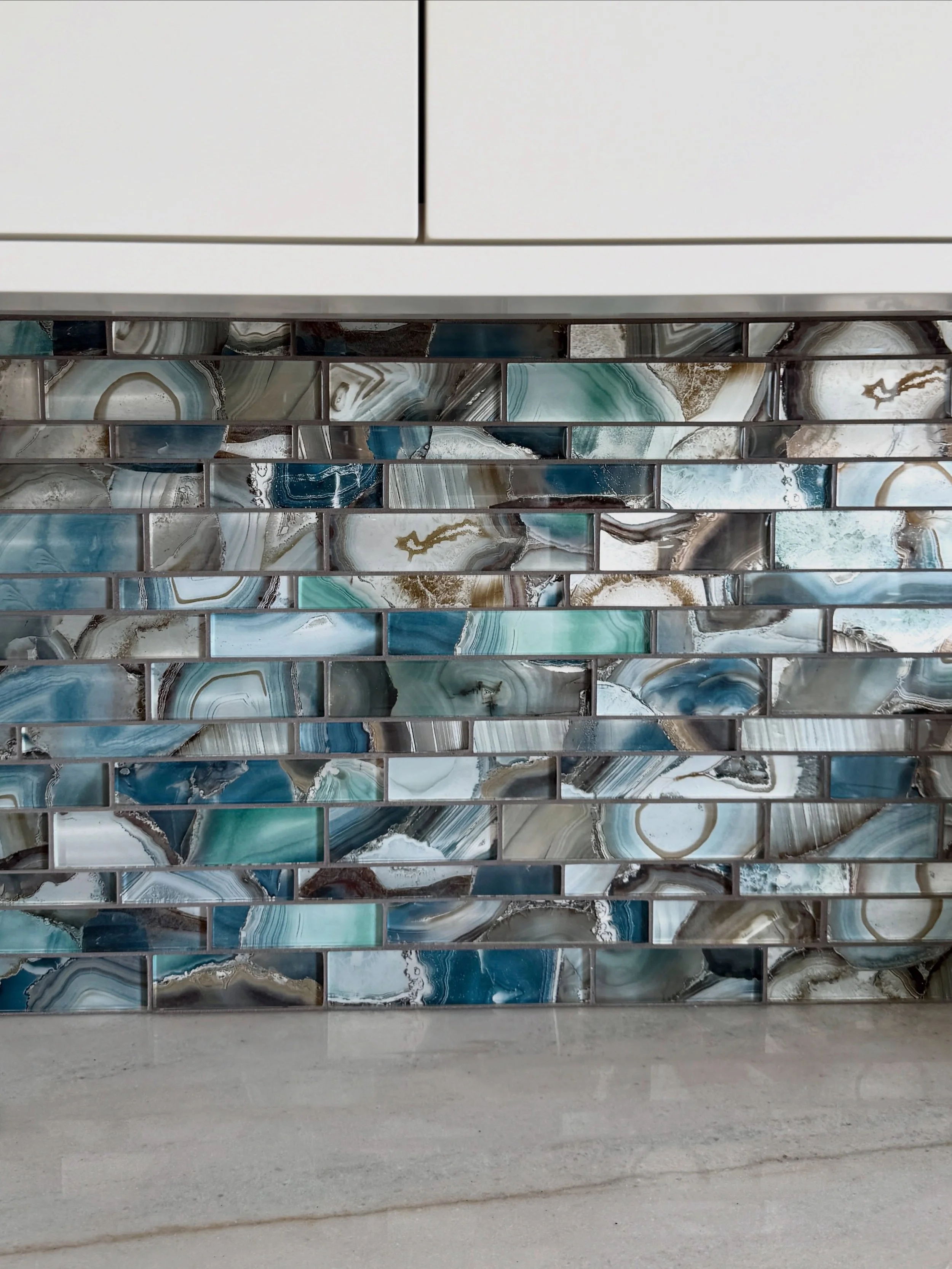 When you live on the ocean, your home becomes an extension of the natural beauty just outside your windows. For this new kitchen, our clients selected this @glazziotiles that reflects the ever-changing colors of the sea - iridescent finishes, rich bl