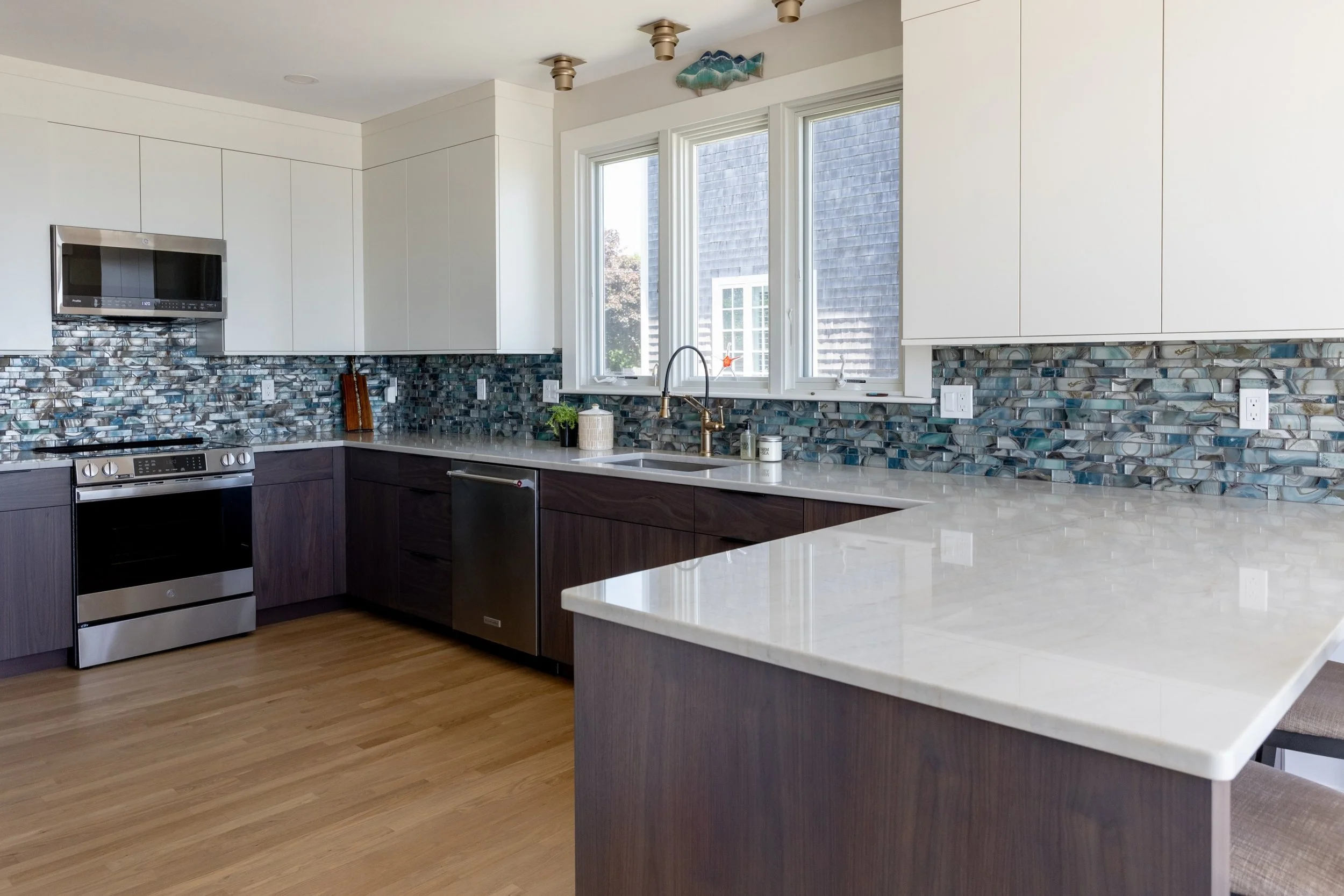 Before ➡️ after kitchen in Swampscott. 

We recently finished this complete kitchen transformation featuring custom cabinetry, quartzite countertops, a stunning blue glass backsplash from @glazziotiles, and a more open, functional layout. Proof that 