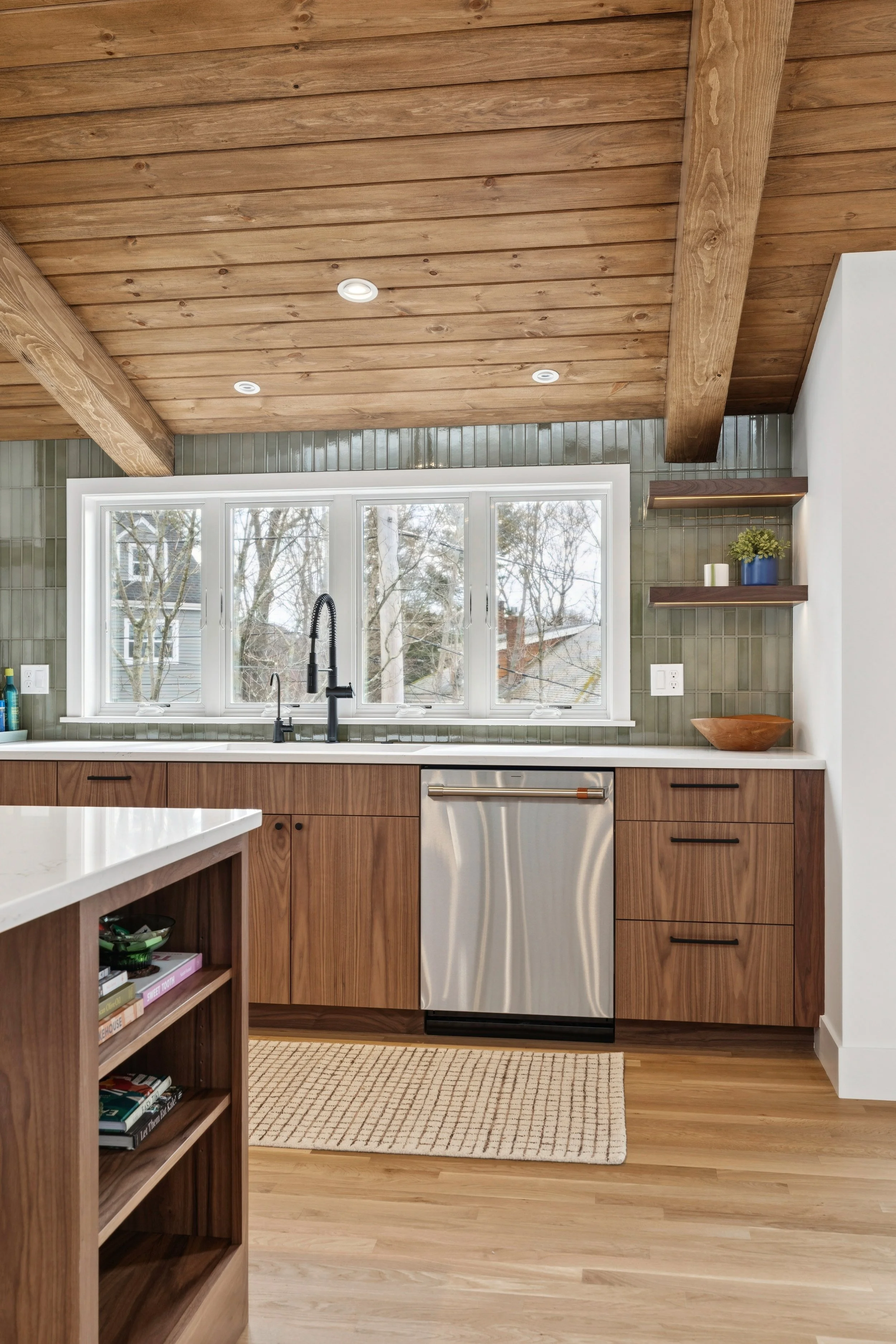 Kitchen with green tile and walnut cabinets