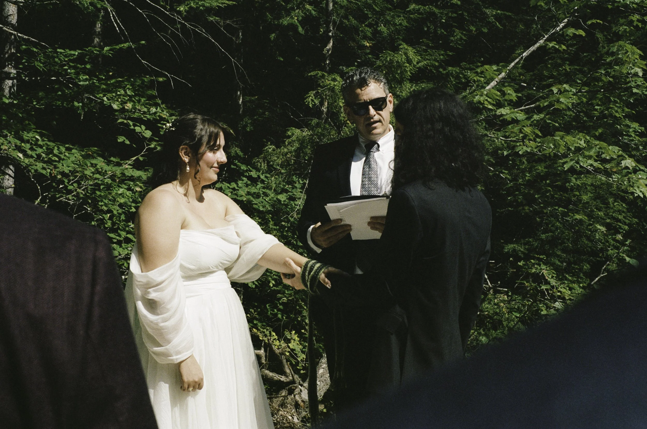 Bride and groom standing across from eachother at their marital altar tying their celtic knot at Dianas Baths in New Hampshire.