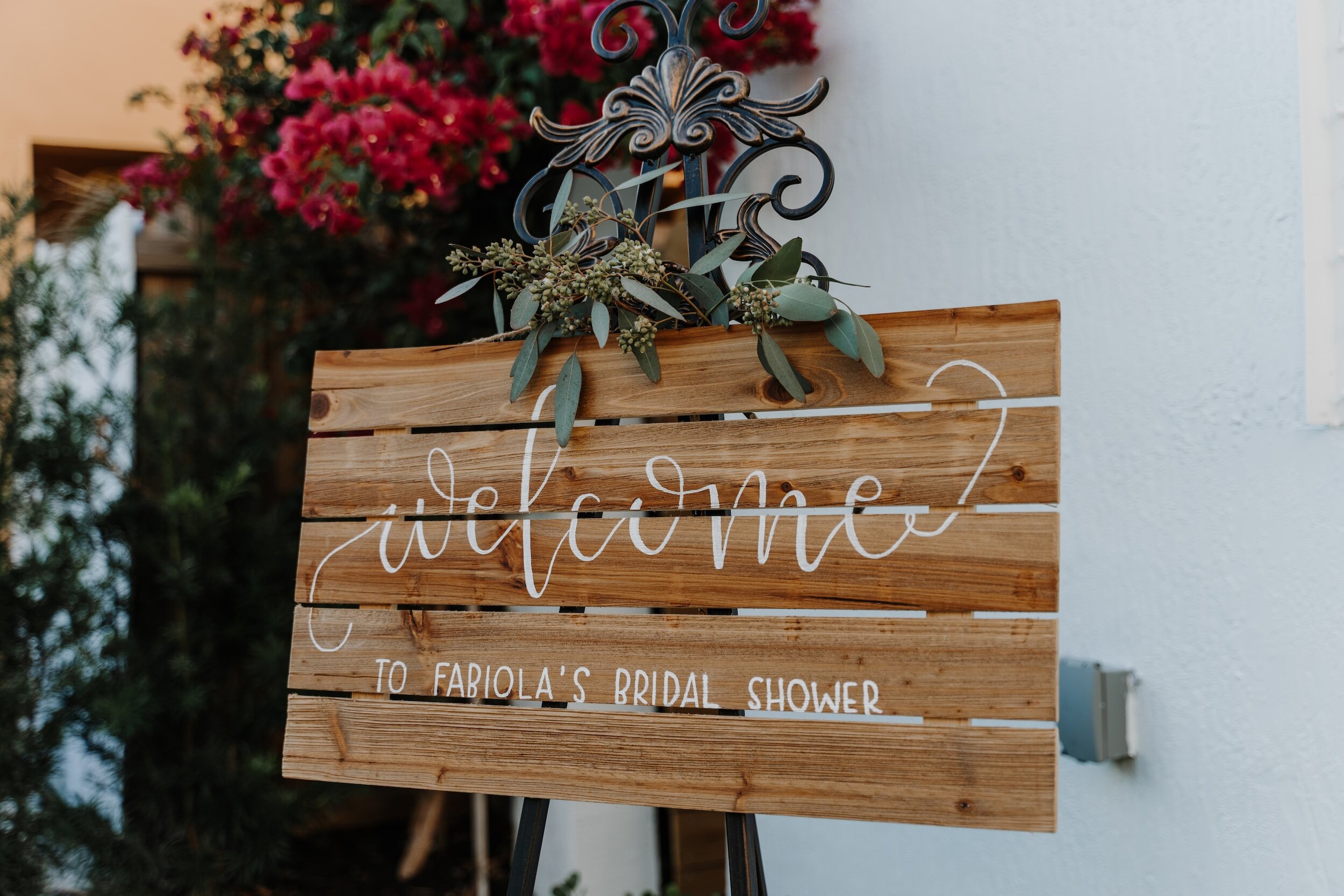 a wooden welcome sign reading "welcome to Fabiola's bridal shower."
