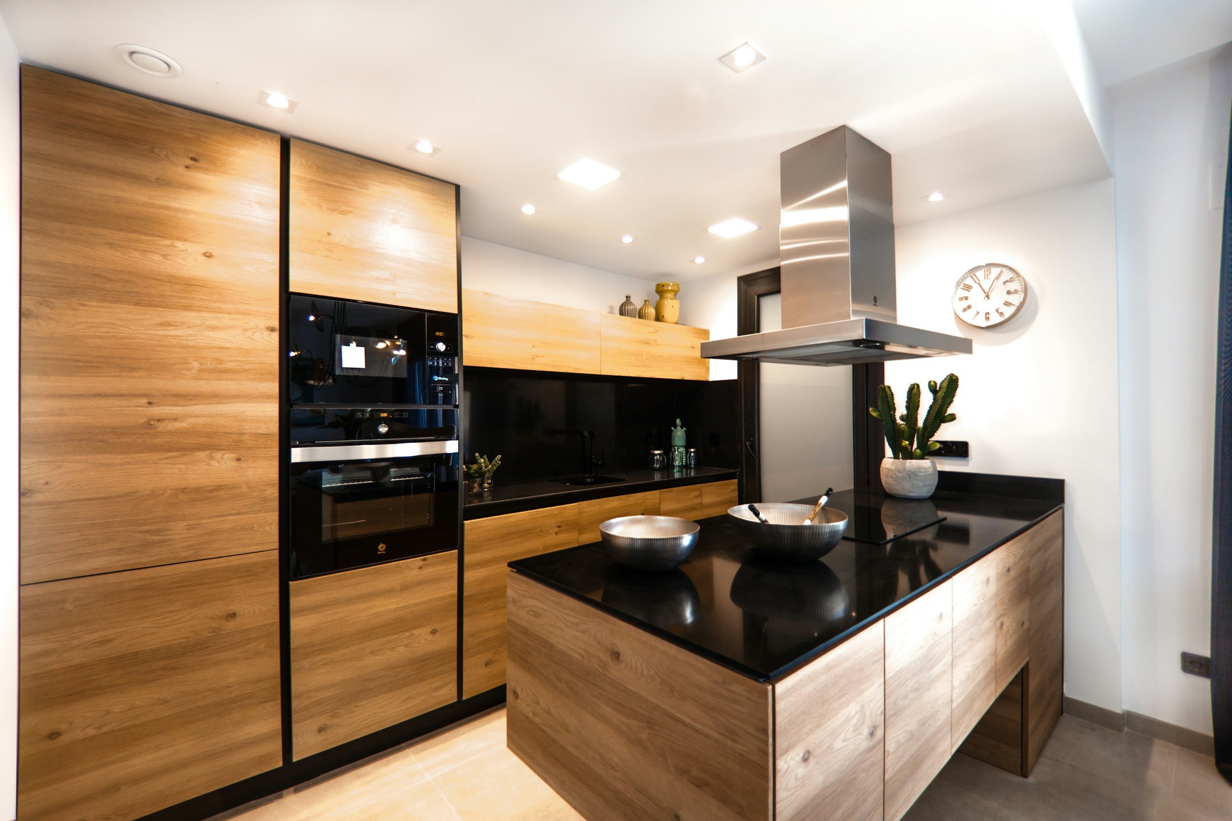 Warm modern kitchen with wood cabinetry and a black island