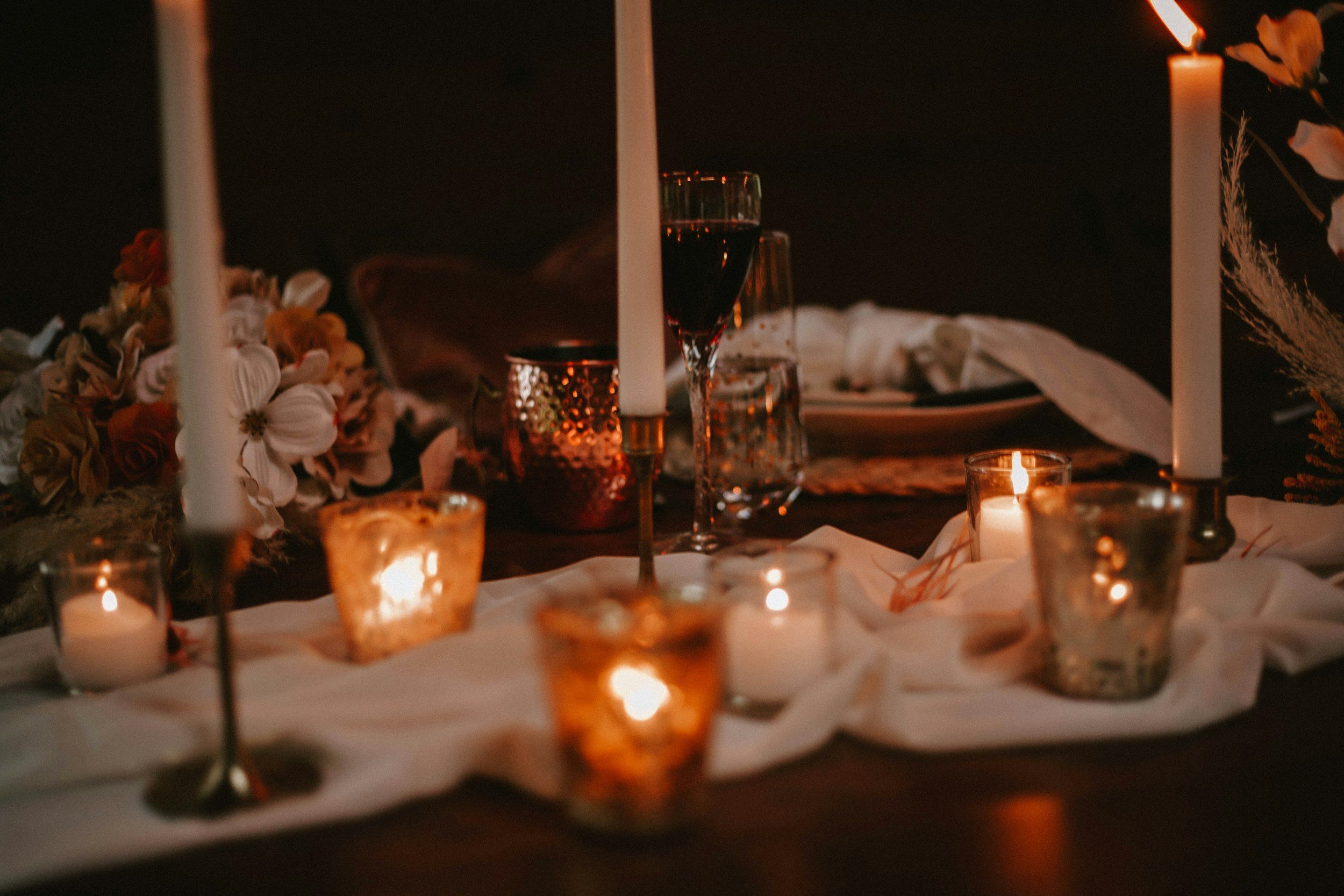 Candlelit wedding table with warm taper candles and glassware for an elegant New Year's Eve reception