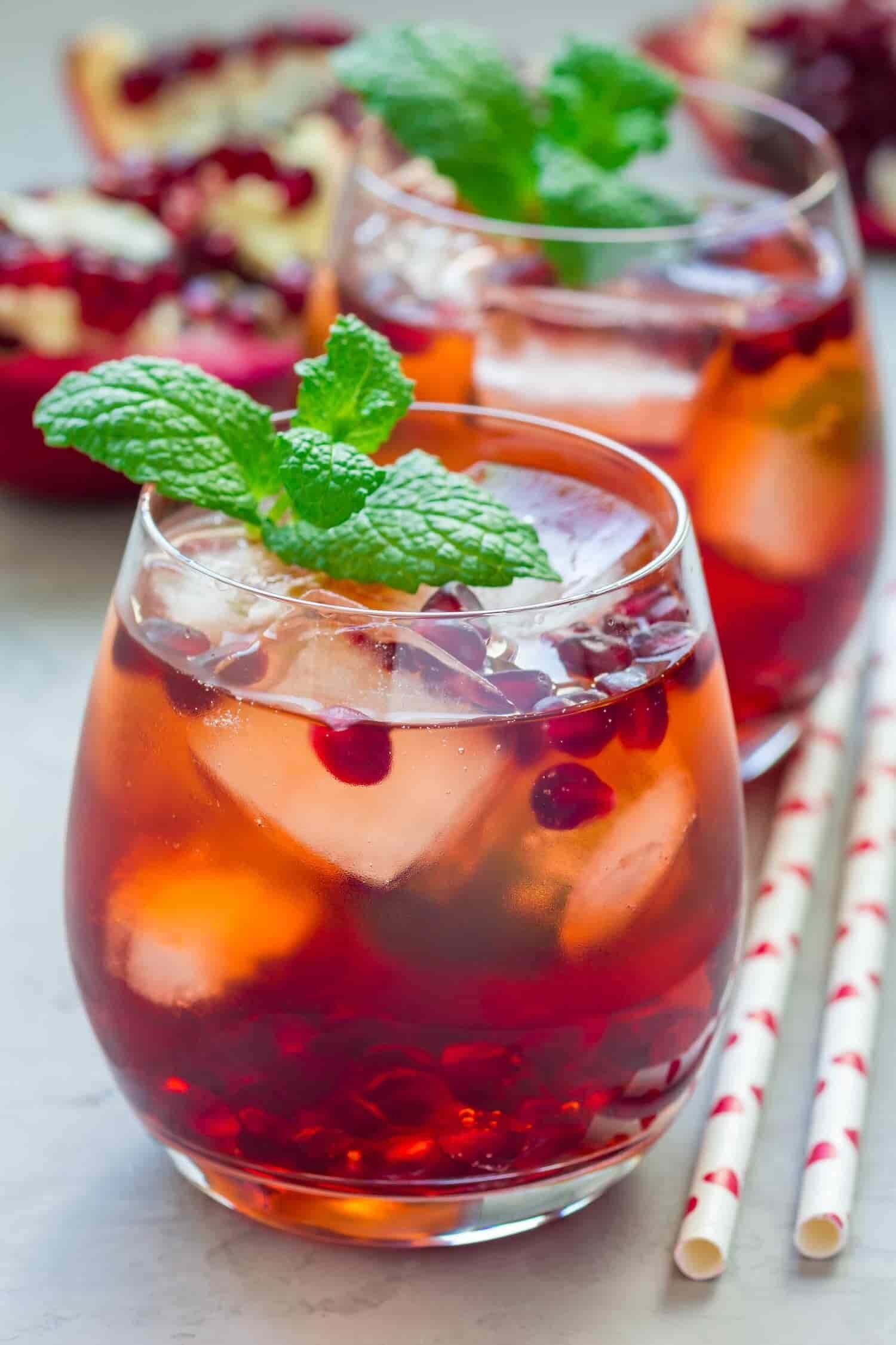 Red cocktails with mint and pomegranate seeds.