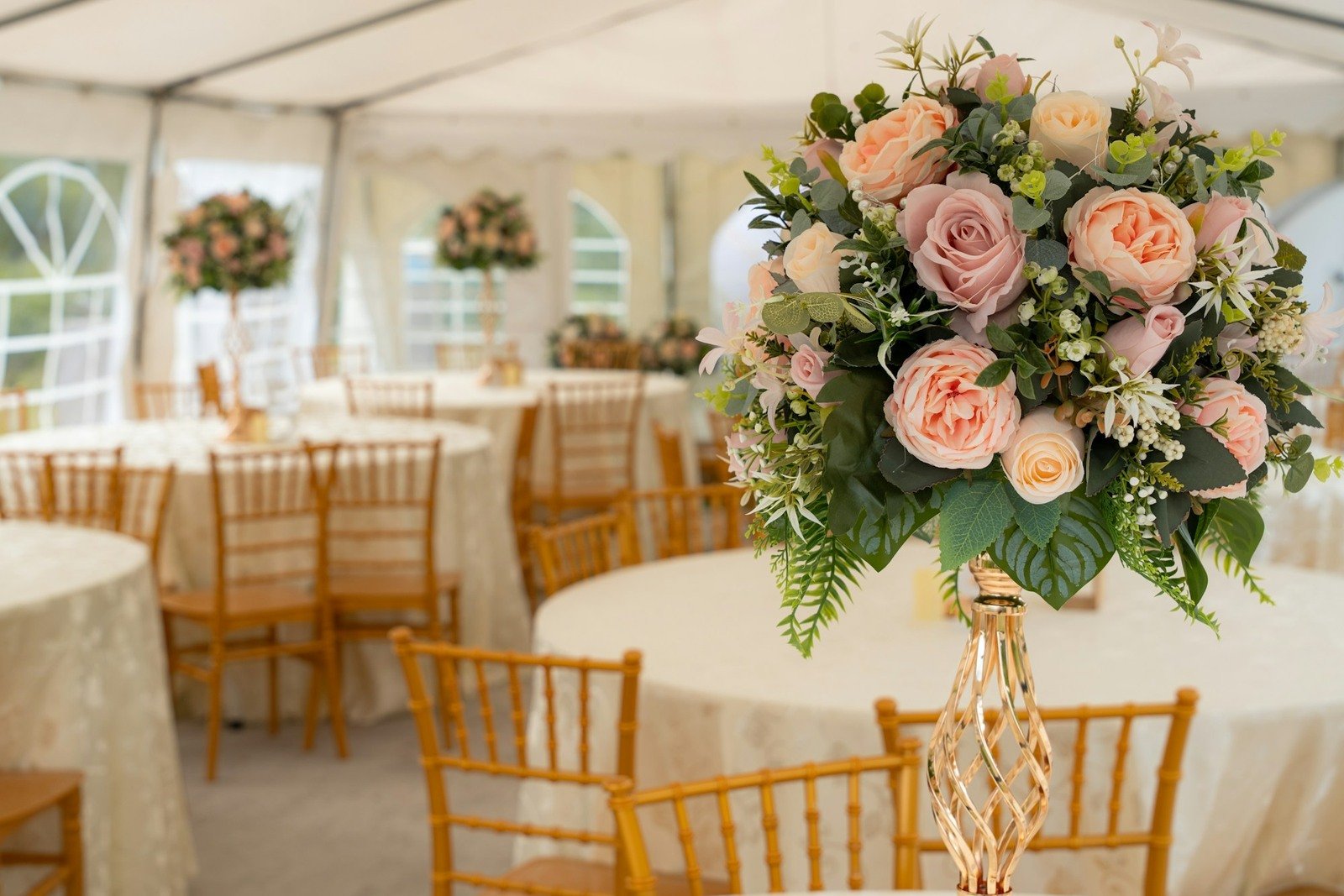Winter wedding reception tent with elegant floral centerpieces and candlelight