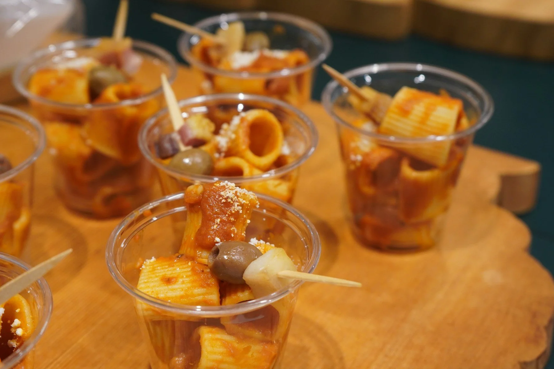 Individual pasta cups prepared for an event buffet