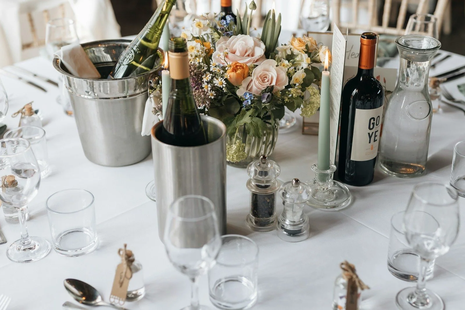 Ivory candles and winter greenery arranged as an elegant wedding centerpiece