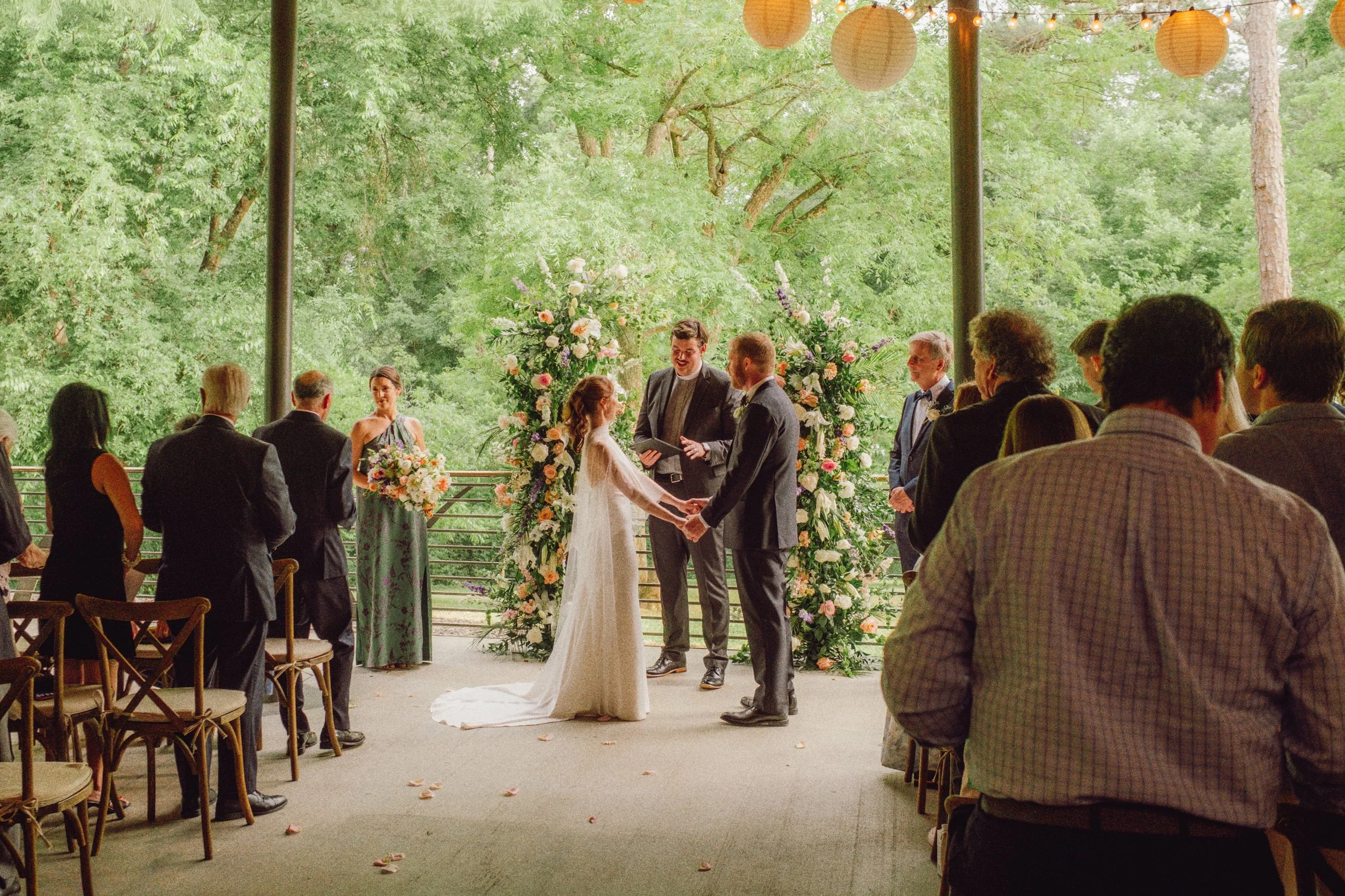 Wedding ceremony under the open-air pavilion at the Museum of Arts and Sciences, with guests standing and paper lanterns overhead