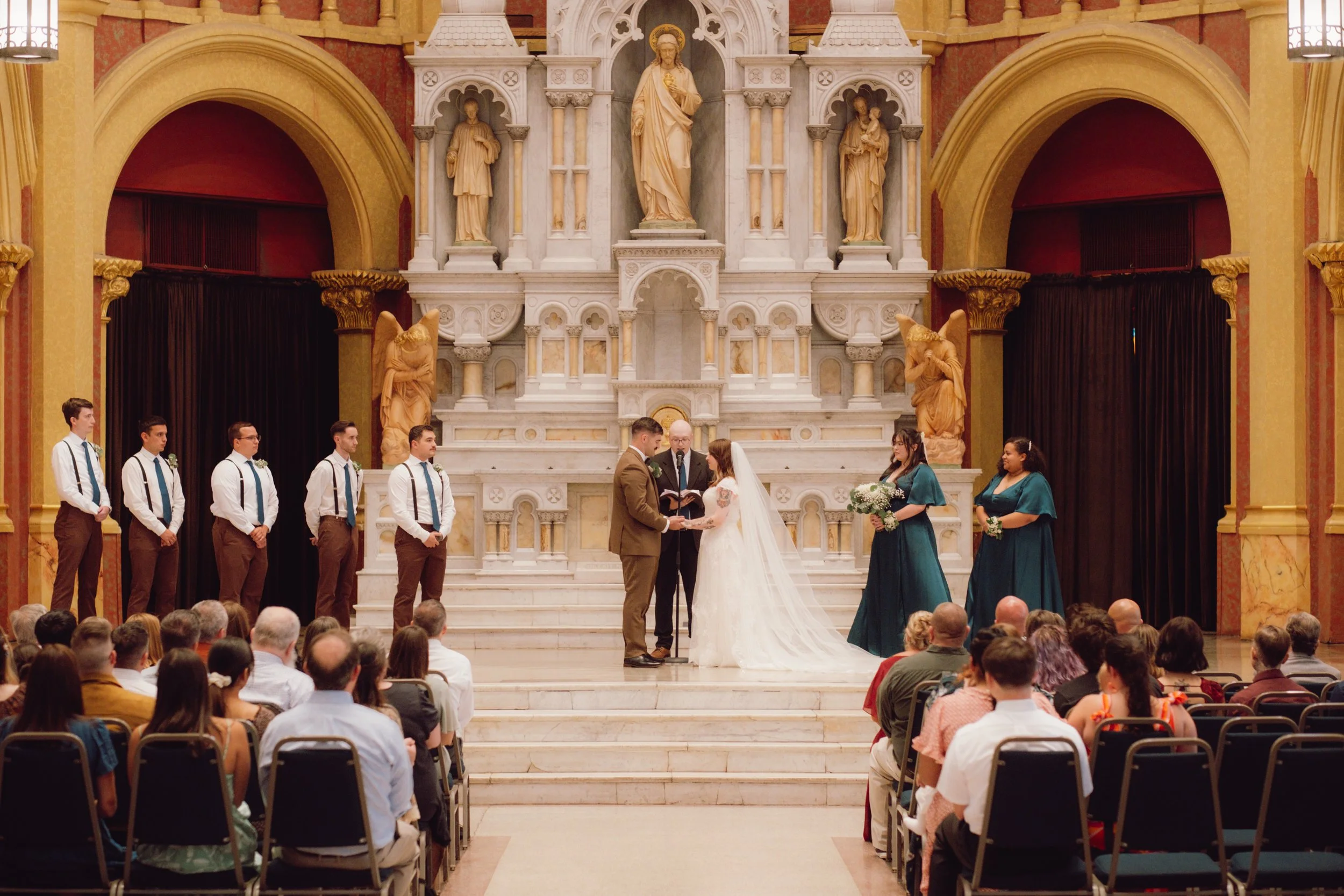 Wedding ceremony at the marble altar of Sacred Heart Cultural Center in Augusta, Georgia with wedding party and guests